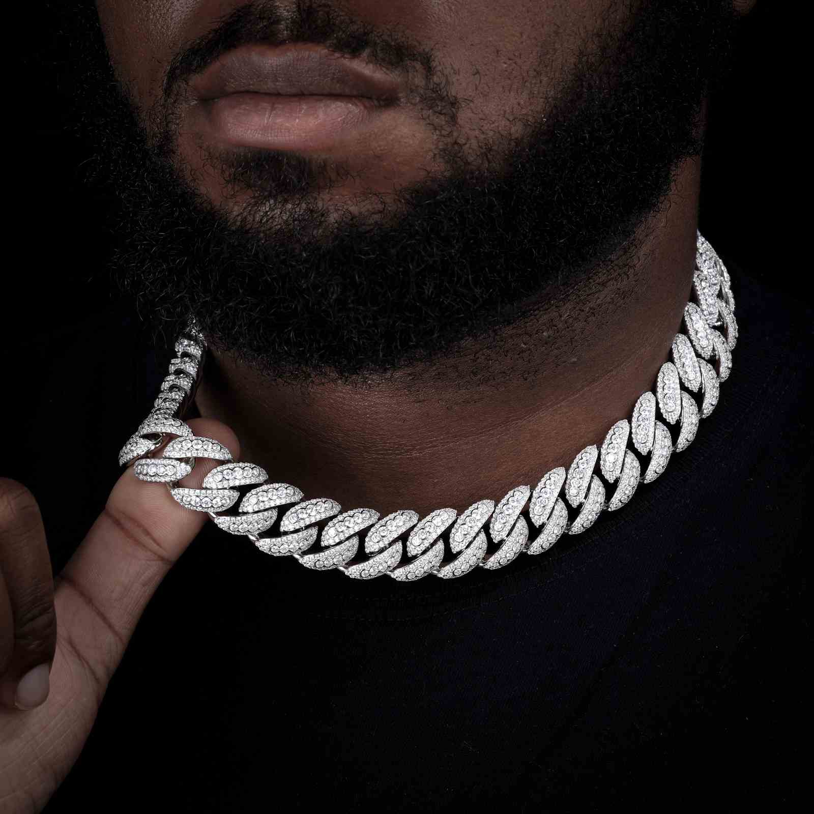 Confident Black male model styling the 18mm white gold-plated Star Trails Cuban link chain. Features eco-brass construction, fade-resistant plating, and full-pave zirconia stones for bold hip-hop streetwear appeal