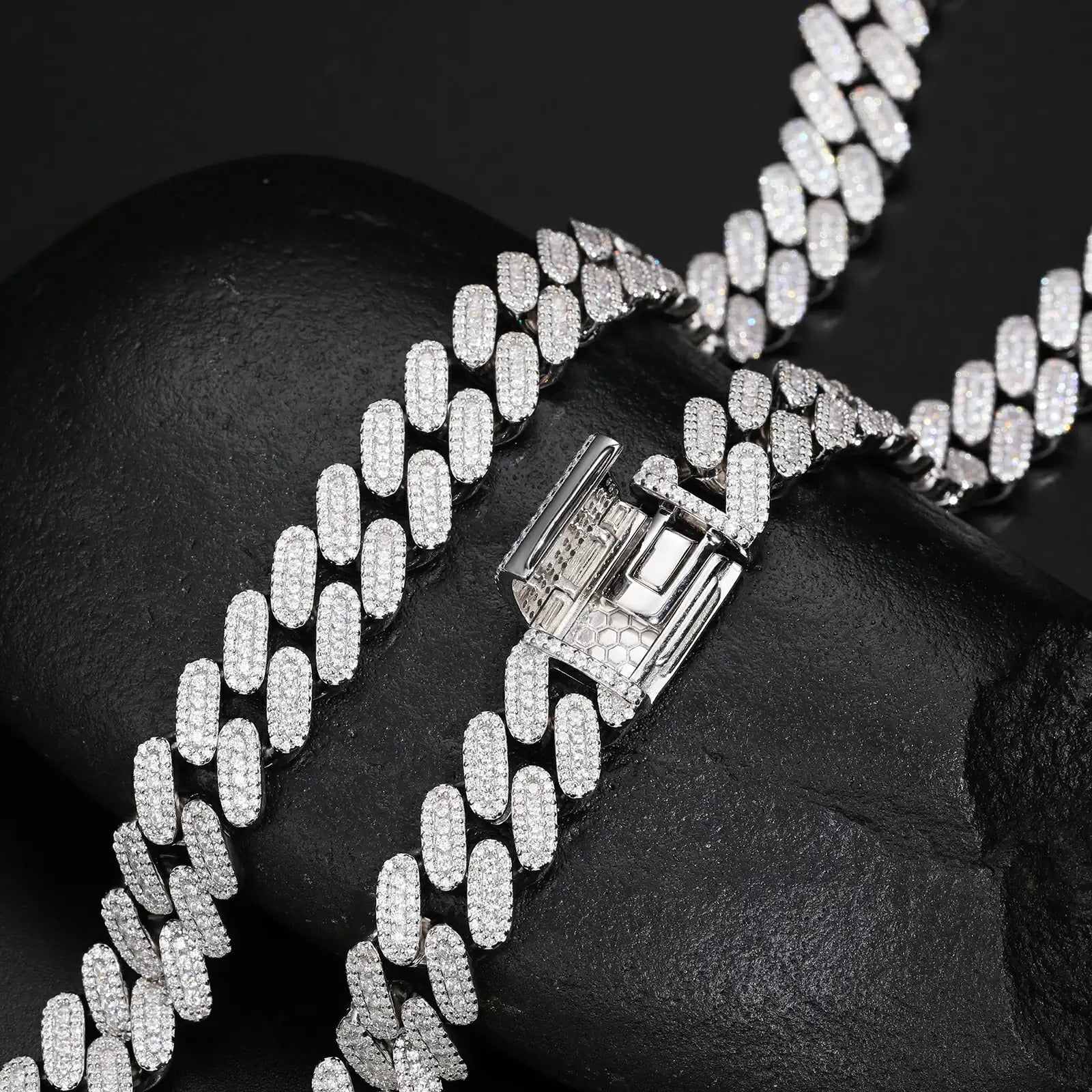 Close-up of 12mm white gold 925 sterling silver 3 row moissanite Cuban link bracelet chain & clasp on black table — highlighting moissanite glow & secure fit