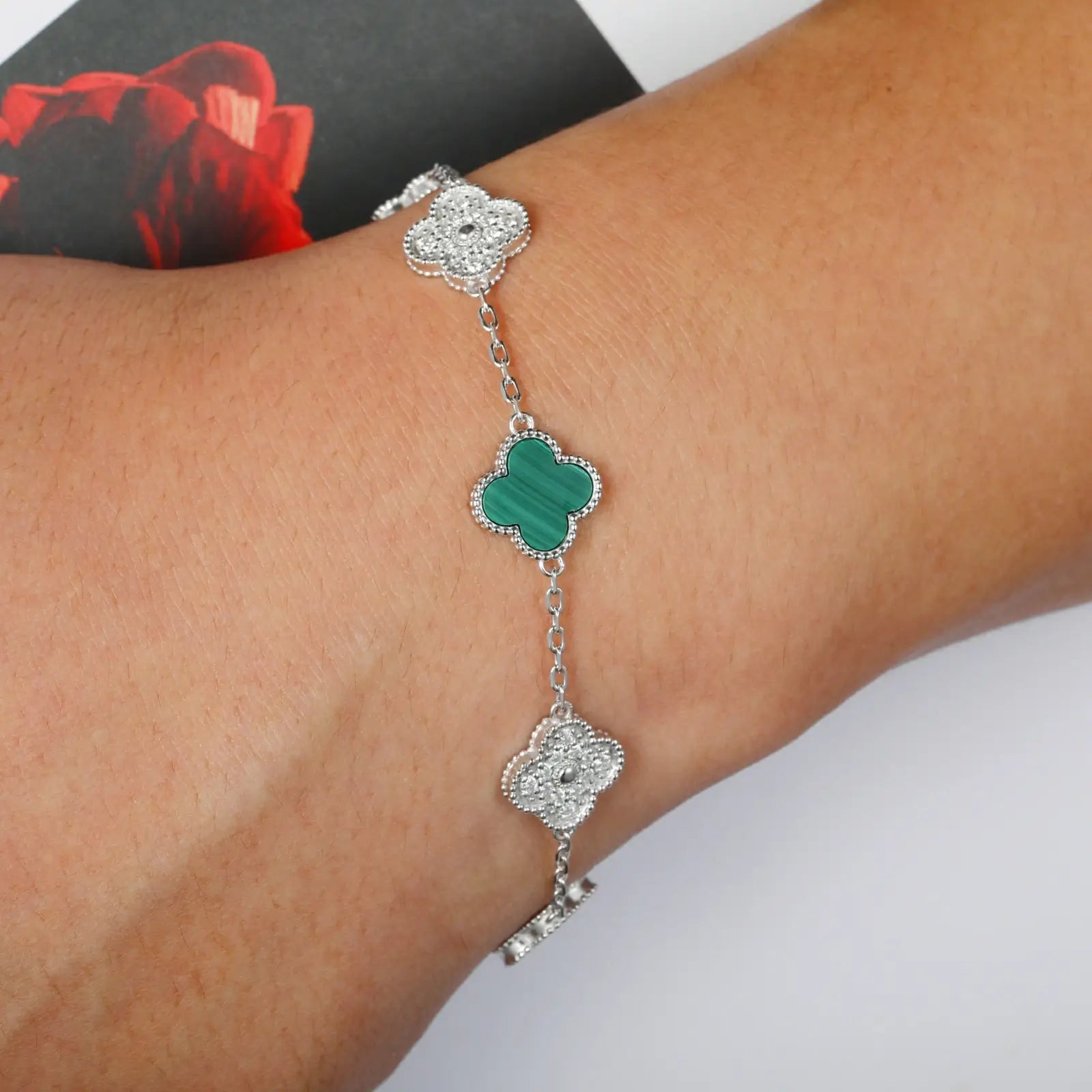 Model wearing malachite 925 sterling silver moissanite 5 clover bracelet on light background — showcases versatile styling, floral luxury trend, moissanite durability