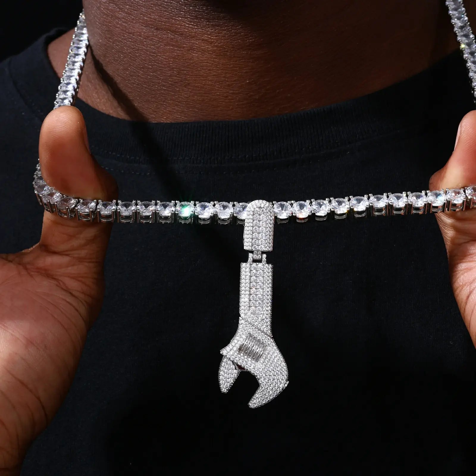 Silver 925 sterling silver moissanite wrench pendant being adjusted on neck — wearable industrial design, moissanite sparkle, 925 silver longevity, streetwear statement