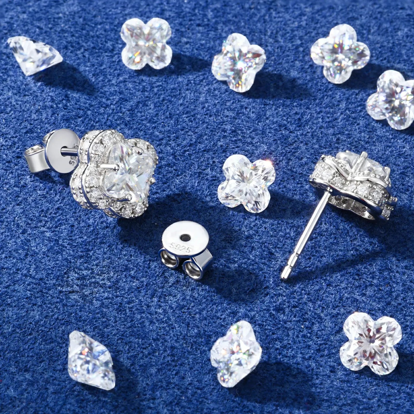 Back close-up of white gold 925 sterling silver lily cut moissanite four leaf clover stud earring on blue table — showcasing 925 silver post, secure backing, clover design craftsmanship from behind