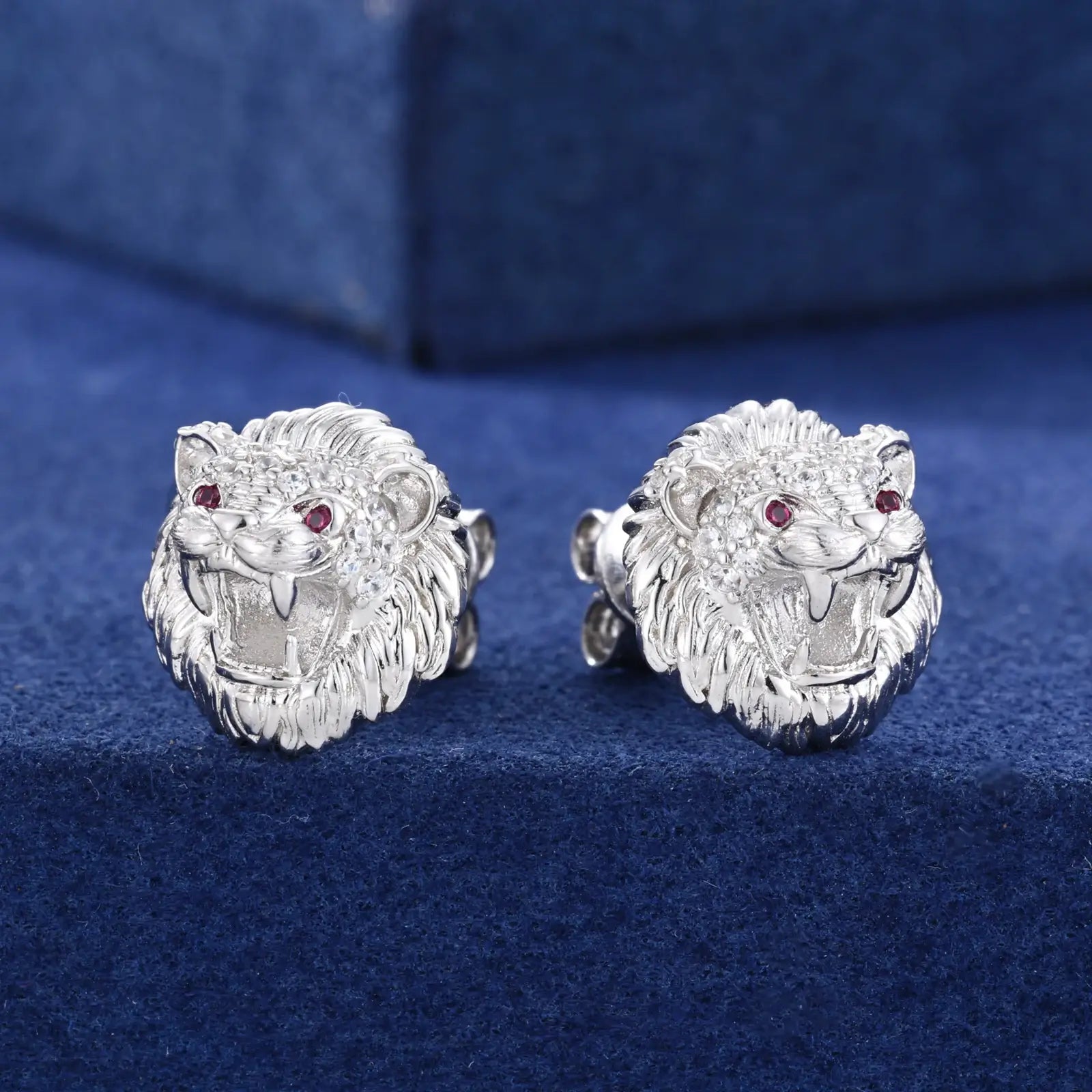 Side close-up of white gold 925 sterling silver moissanite little lion stud earring on blue table — highlighting moissanite detailing, lion texture, 925 silver build