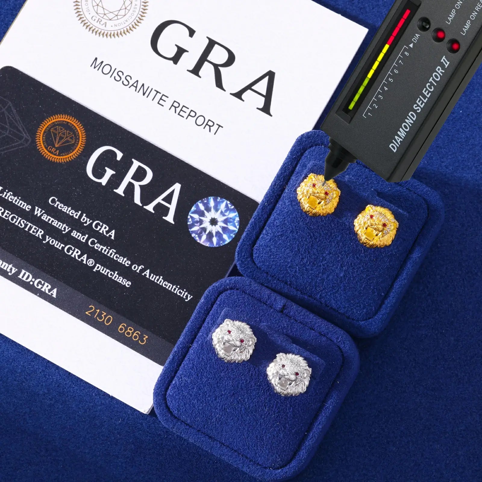 White & yellow gold 925 sterling silver moissanite little lion stud earrings with diamond tester + GRA certificate on blue table — certified moissanite, 925 silver durability, unique lion design