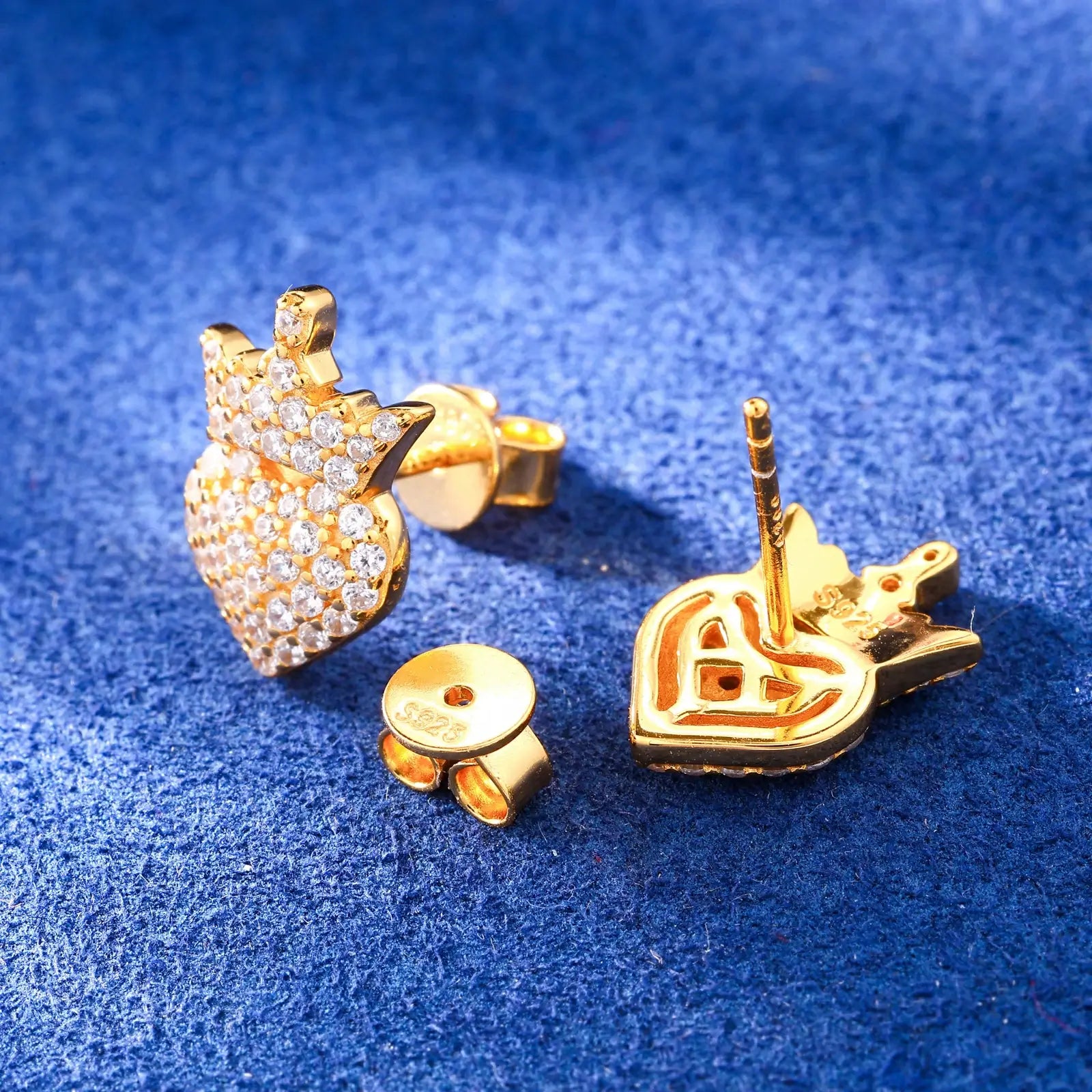 Back close-up of yellow gold 925 sterling silver moissanite crown heart stud earring on blue table — showcasing 925 silver post, secure backing, crown-heart design from behind