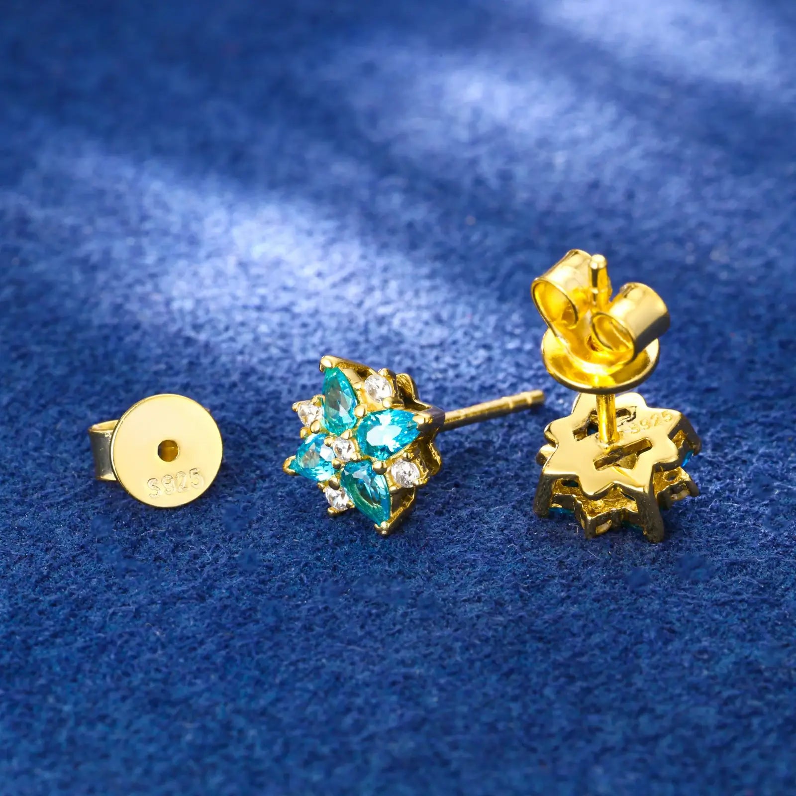 Back close-up of yellow gold 925 sterling silver moissanite lucky star clover stud earring on blue table — showcasing 925 silver post, secure backing, star-clover design from behind with moissanite & zircon