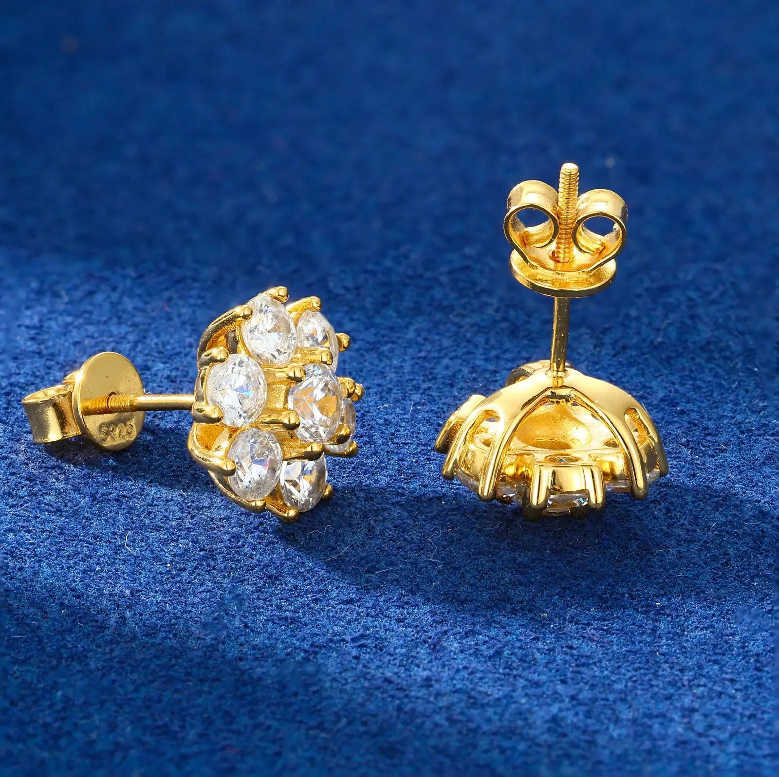Side close-up of yellow gold 925 sterling silver moissanite radiance flower stud earring on blue table — highlighting petal detailing, moissanite texture, 925 silver build