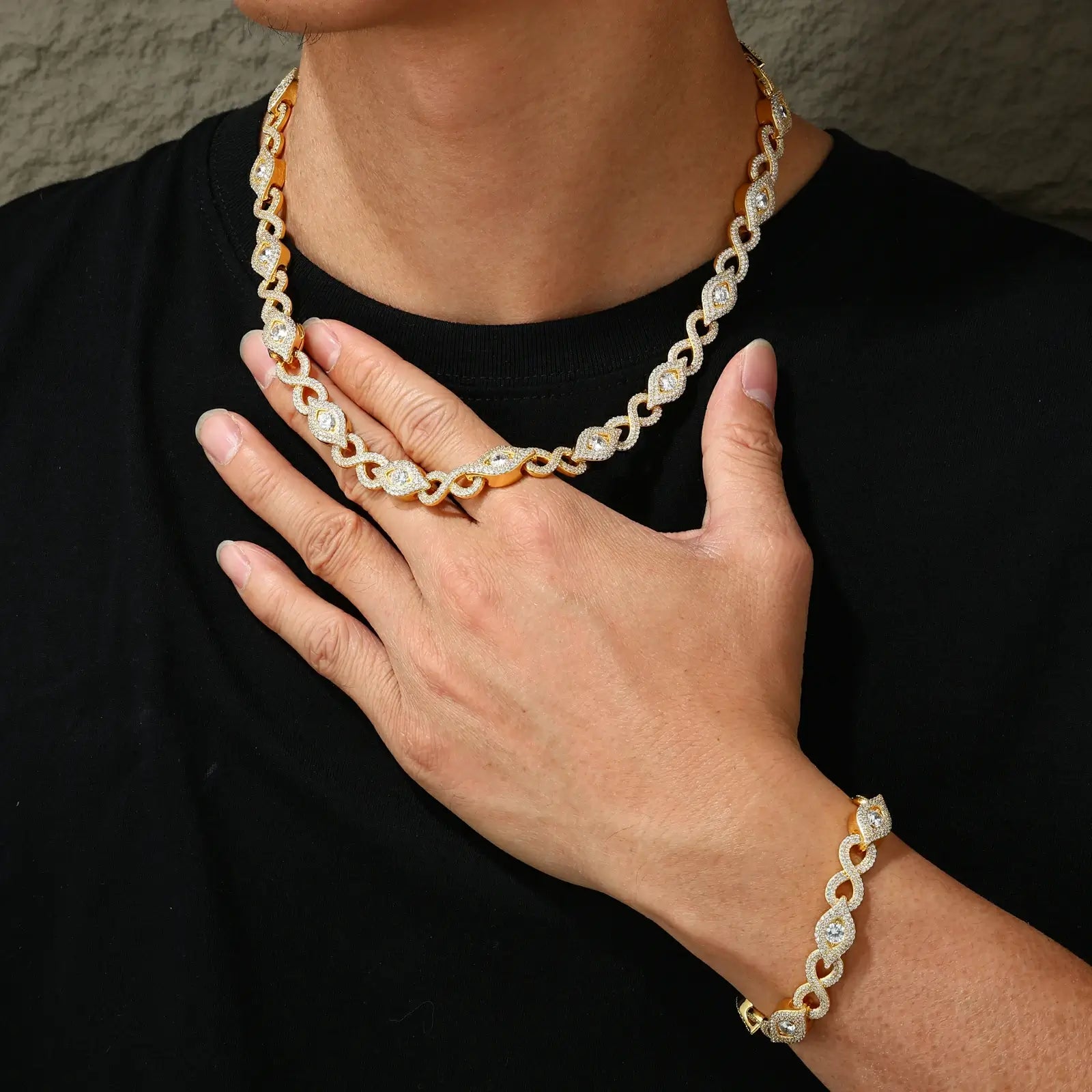 Action shot of 10mm yellow gold Evil Eye chain swaying on male model - showing full necklace length (22") with infinity symbol motifs