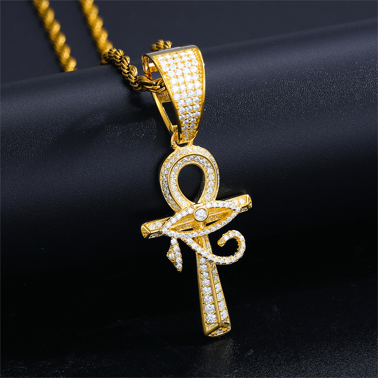 18K gold evil eye ankh cross pendant resting on black marble - VVS moissanite eye radiating 2.65 RI fire | Ancient protection meets modern bling