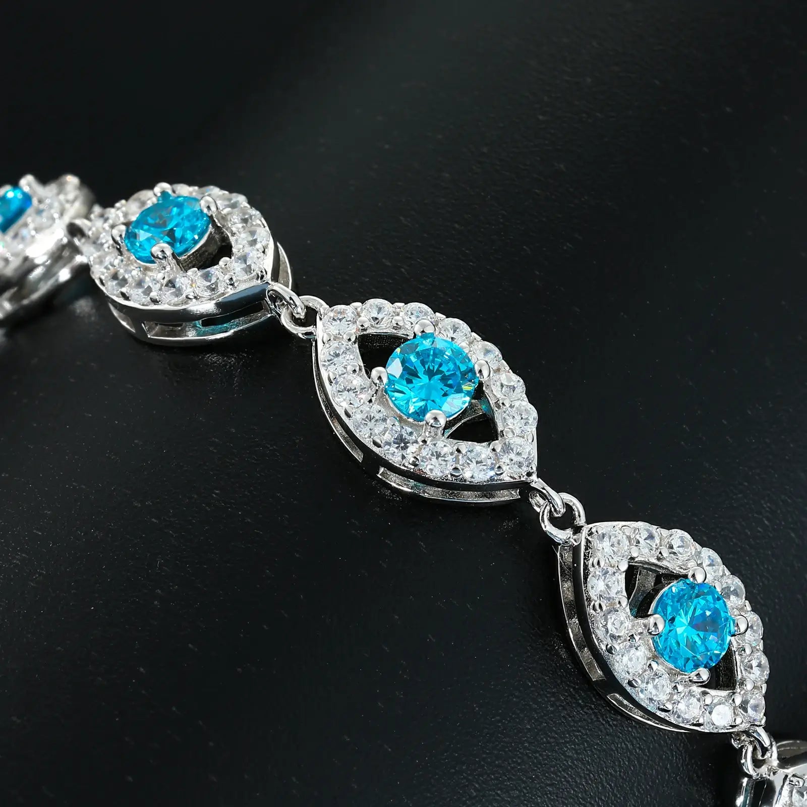 Extreme close-up: Blue VVS moissanite evil eye with white halo stones - 0.3mm prong setting precision | Spiritual guardian detail