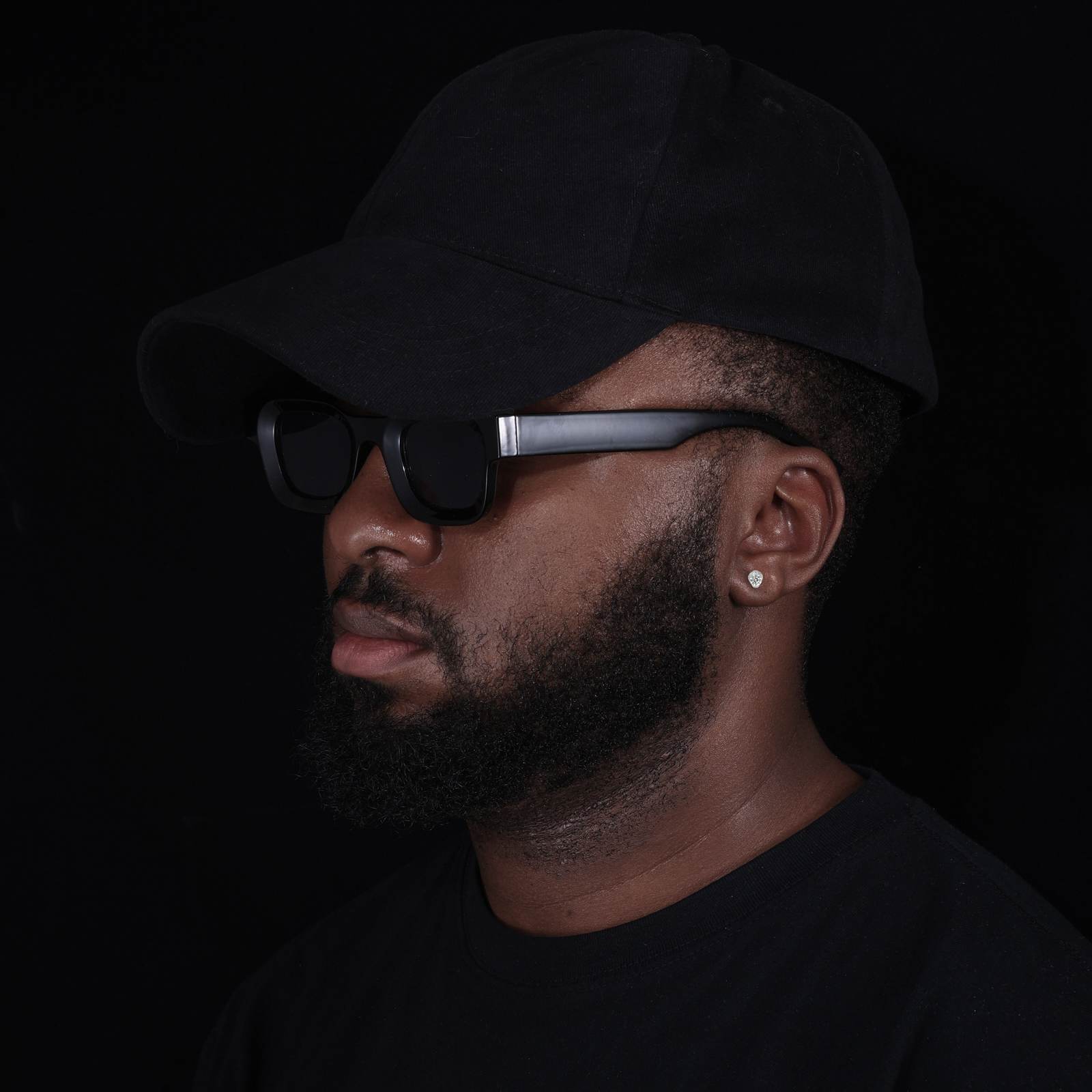 Close-up of African American male model’s ear showcasing cobra stud’s 3D-engraved fang and DEF VVS moissanite sparkle, designed for bold streetwear statements