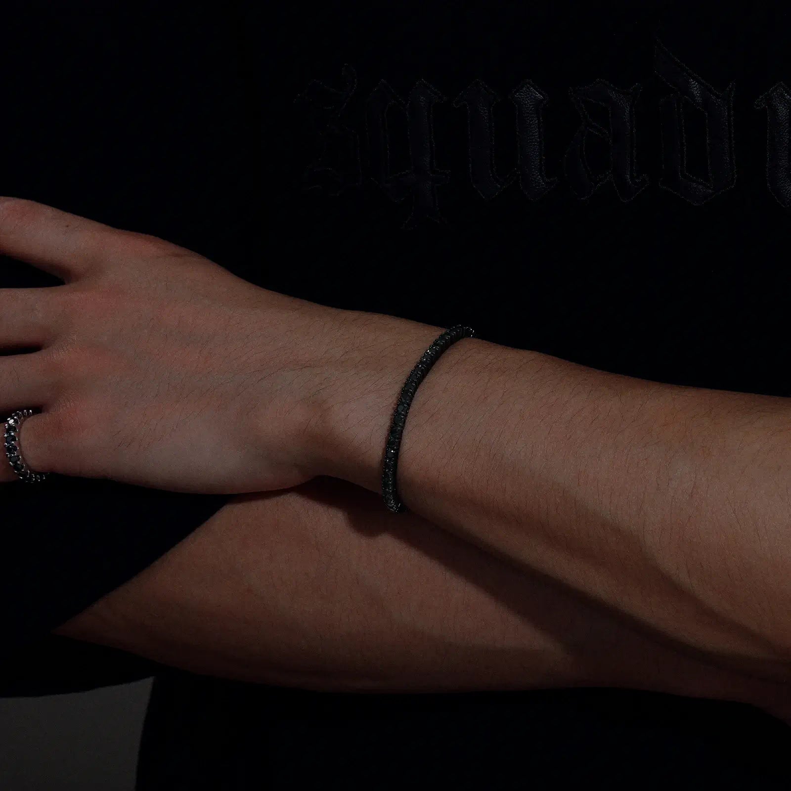 Back view of male model wearing 3mm black moissanite tennis bracelet, showcasing secure closure and 360-degree elegance