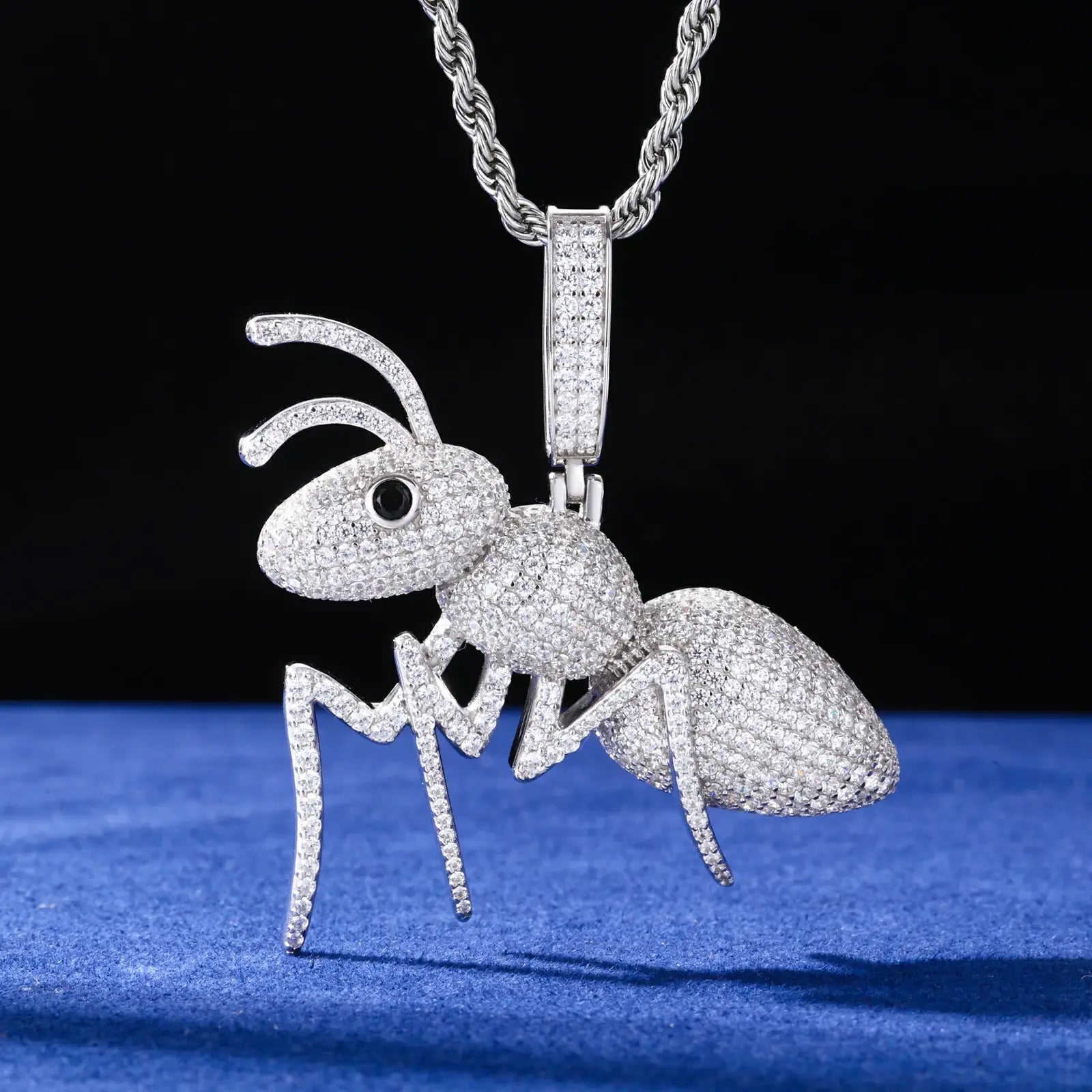 925 sterling silver moissanite ant pendant hanging on blue background, showcasing intricate insect anatomy with pave stone setting