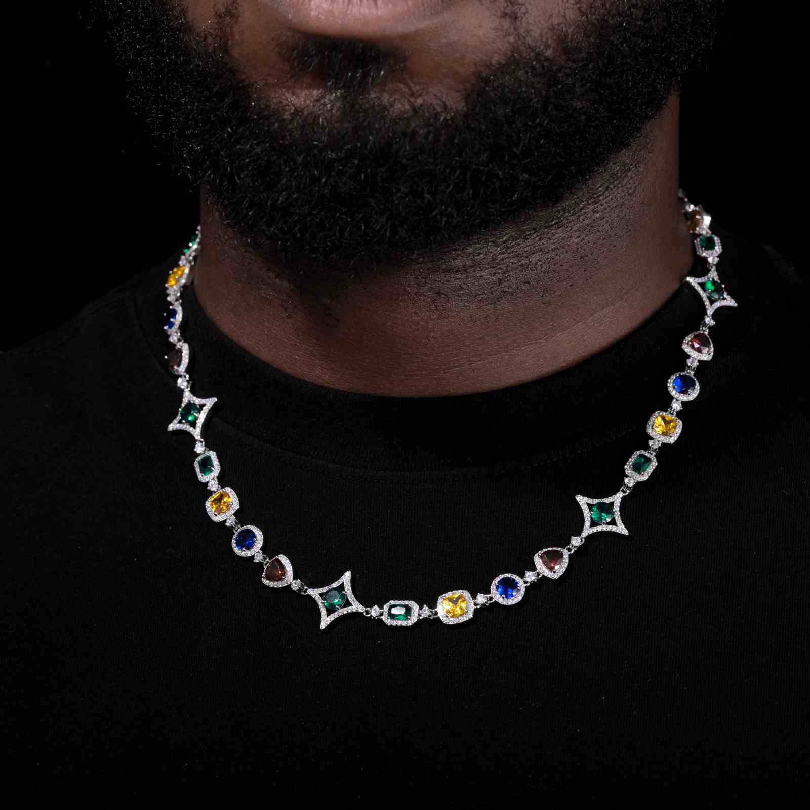 Close-up of white gold chain’s star and halo design resting on a male model’s chest, highlighting DEF moissanites and vibrant zirconia accents