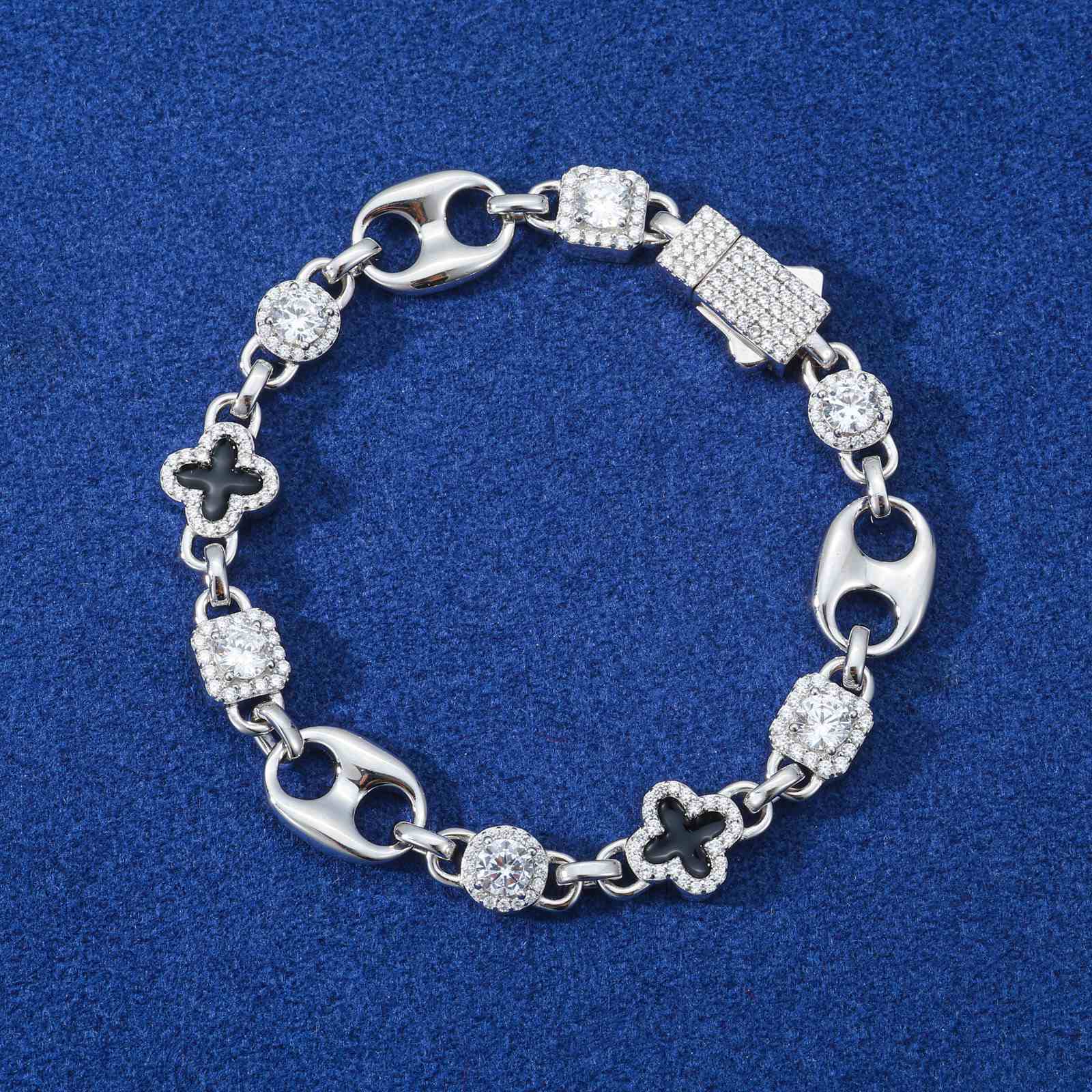 10mm Gucci-inspired four leaf clover bracelet with moissanites and enamel on navy marble, reflecting studio lighting for luxury streetwear