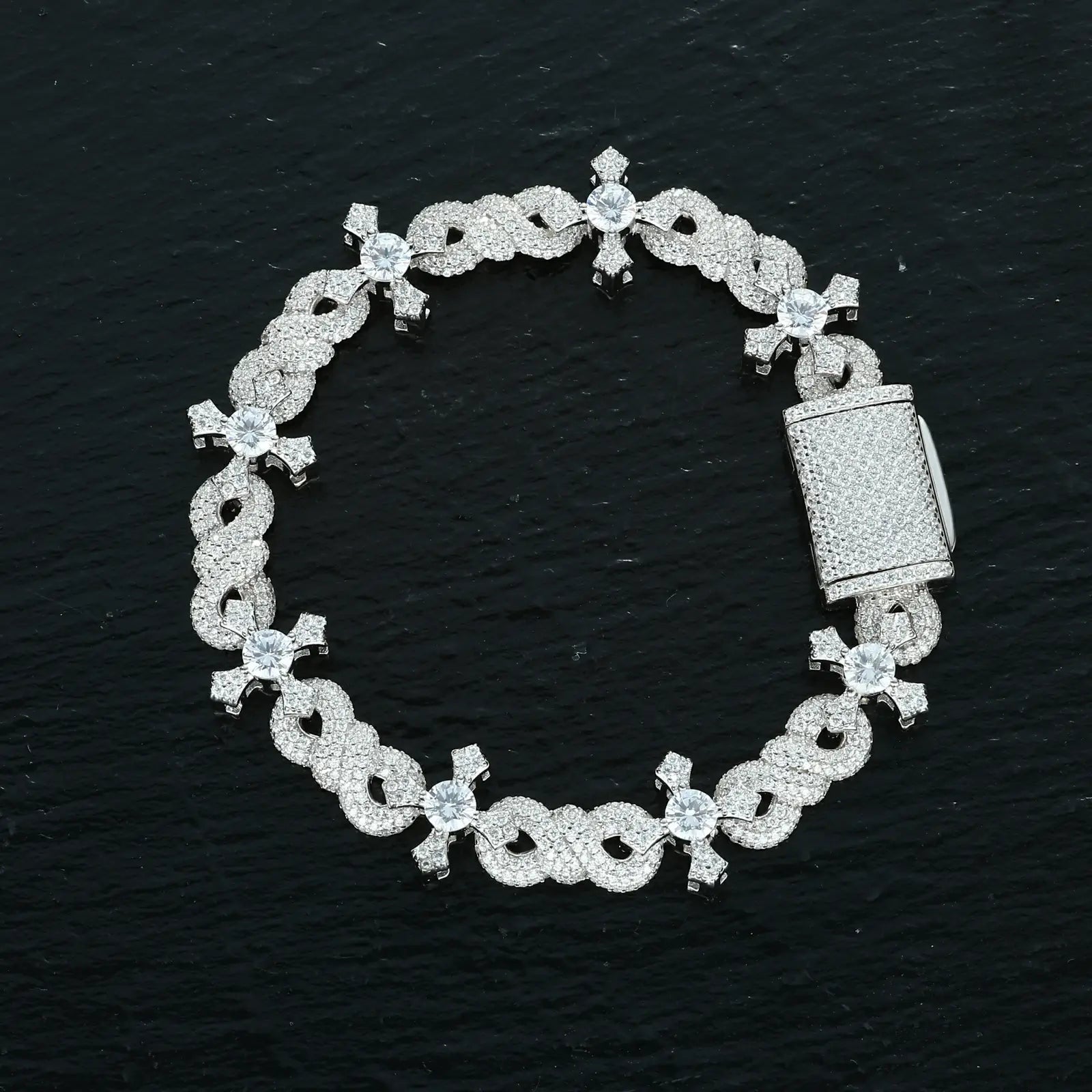 13mm white gold bracelet on black surface - infinity loops embracing cross charms | Tarnish-proof S925 construction