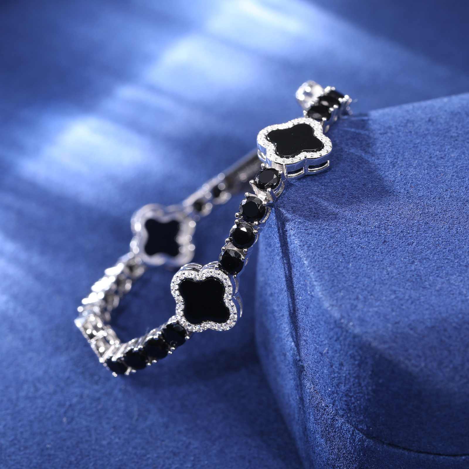 Side angle of black enamel four-leaf clover bracelet, emphasizing textured enamel details and secure S925 silver clasp.