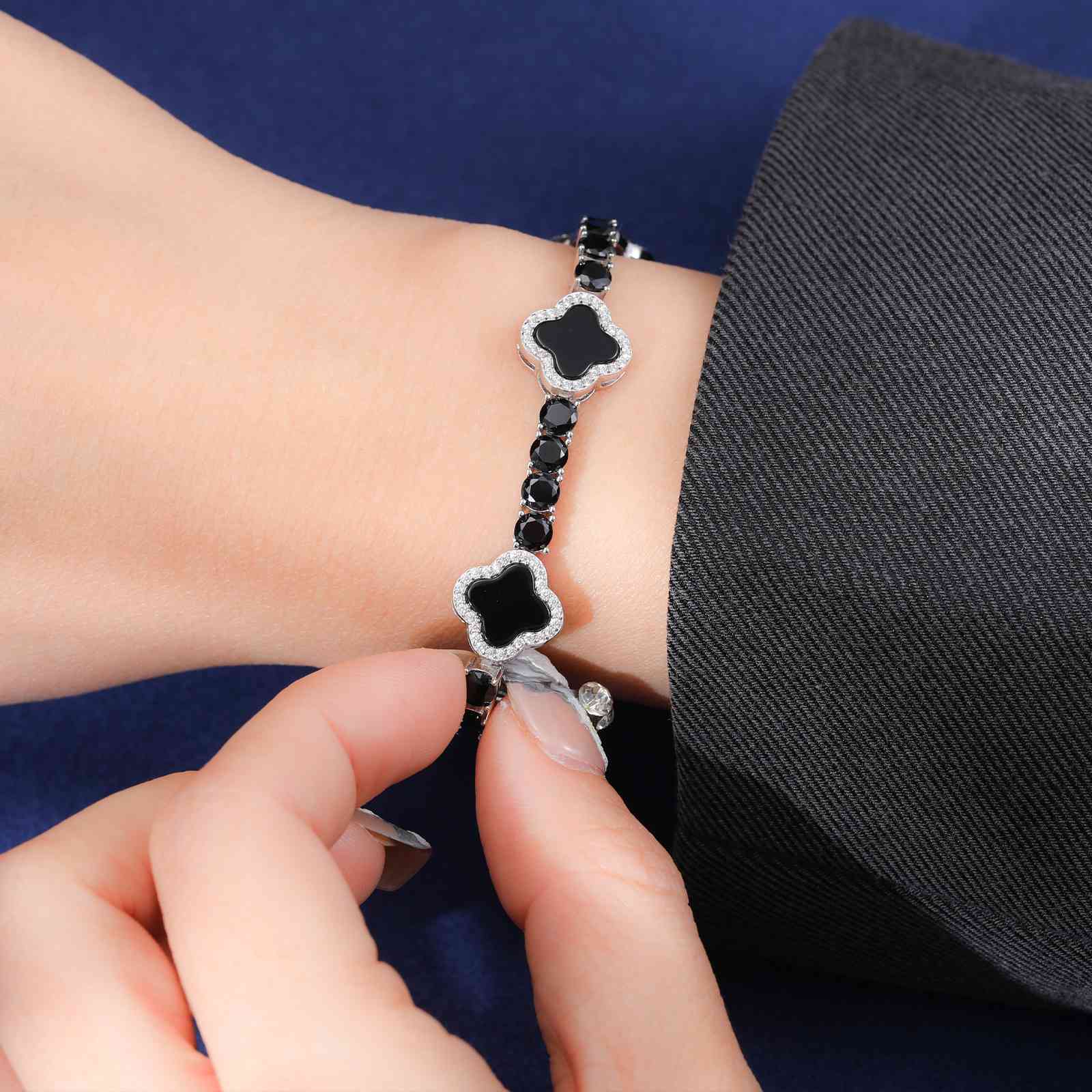 Sophisticated black enamel four-leaf clover bracelet on a model’s wrist, showcasing sleek design and hypoallergenic S925 silver durability.