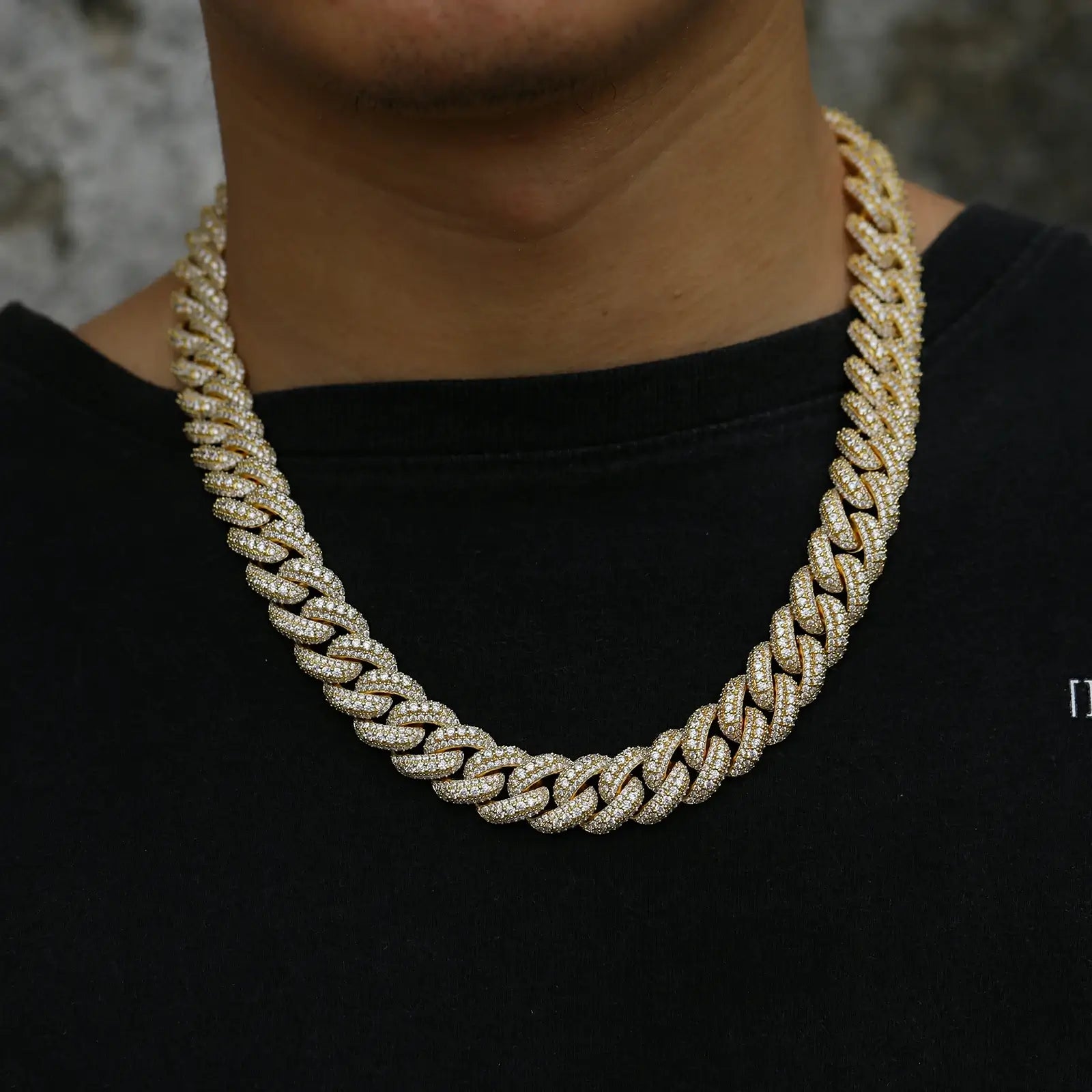 Stylish model showcasing a bold 15mm yellow gold Cuban chain with lab-created moissanite stones, ideal for making a luxury statement.
