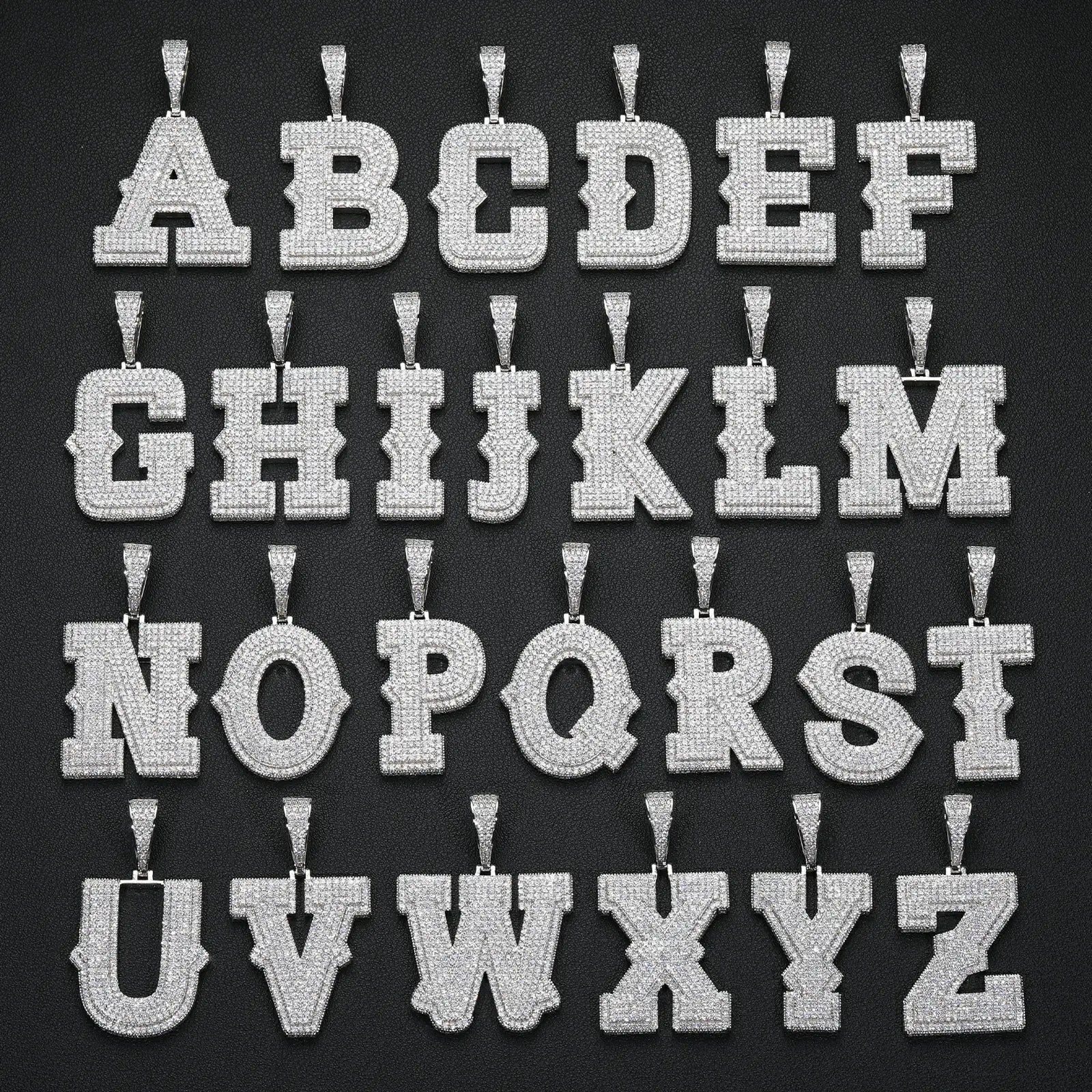 26 white gold 925 sterling silver moissanite initial letter pendants displayed on black table — personalized bling jewelry