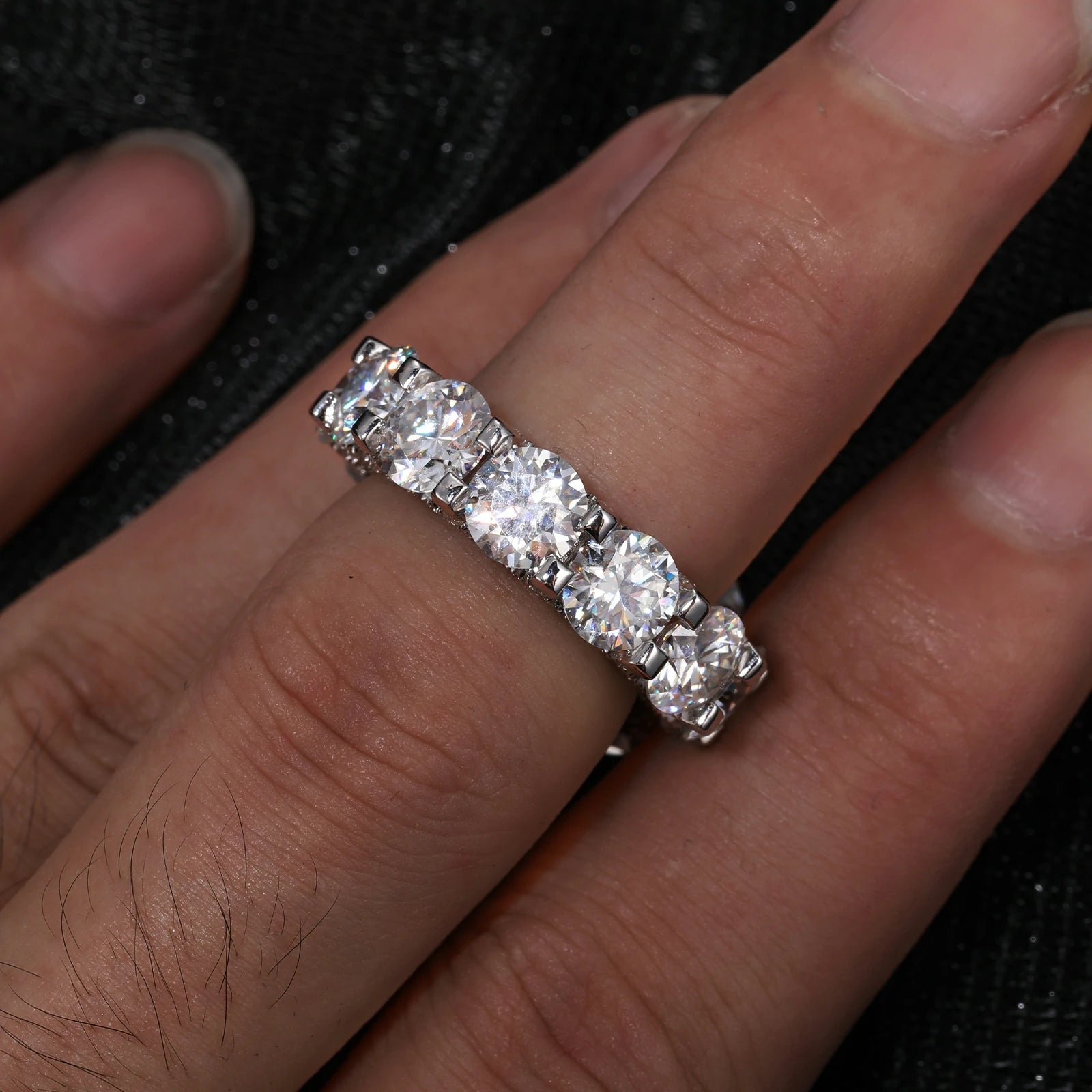 Men modeling a 6.5mm white gold moissanite eternity engagement ring, showcasing its diamond-like sparkle and S925 sterling silver craftsmanship.