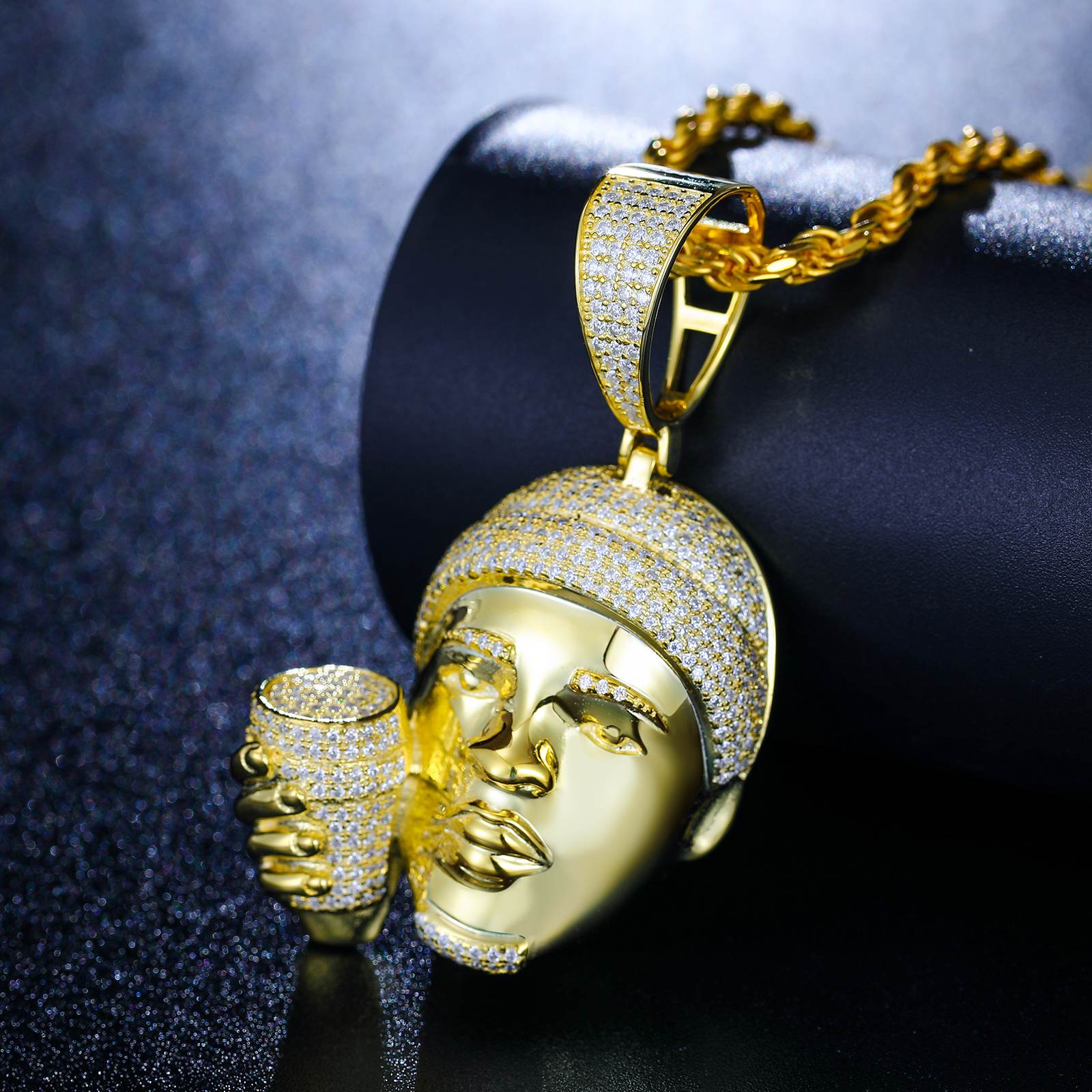 Top-down shot of gold-plated rapper cup pendant on marble - Waterproof 925 silver with precision pave setting