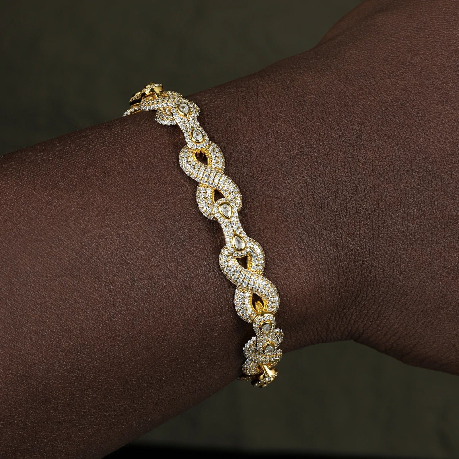 Male model wearing yellow gold 10mm 925 sterling silver moissanite peanut infinity link bracelet — hypoallergenic, diamond-like sparkle luxury streetwear