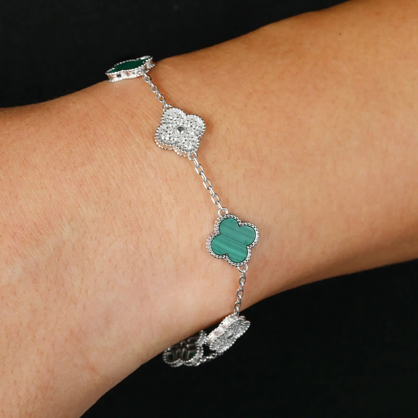 Model wearing malachite 925 sterling silver moissanite 5 clover bracelet on black background — highlights everyday wearability, nature-inspired trend, hypoallergenic 925 silver