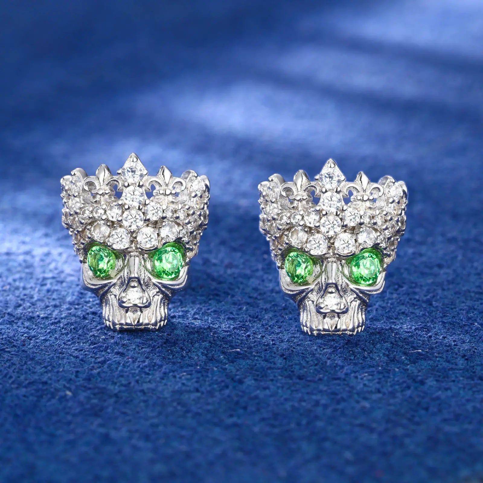 White gold 925 sterling silver moissanite Chrome Hearts crown skull stud earrings full display on blue table — showcasing dark-luxury crown-skull design, moissanite sparkle & zircon vibrancy, 925 silver craftsmanship