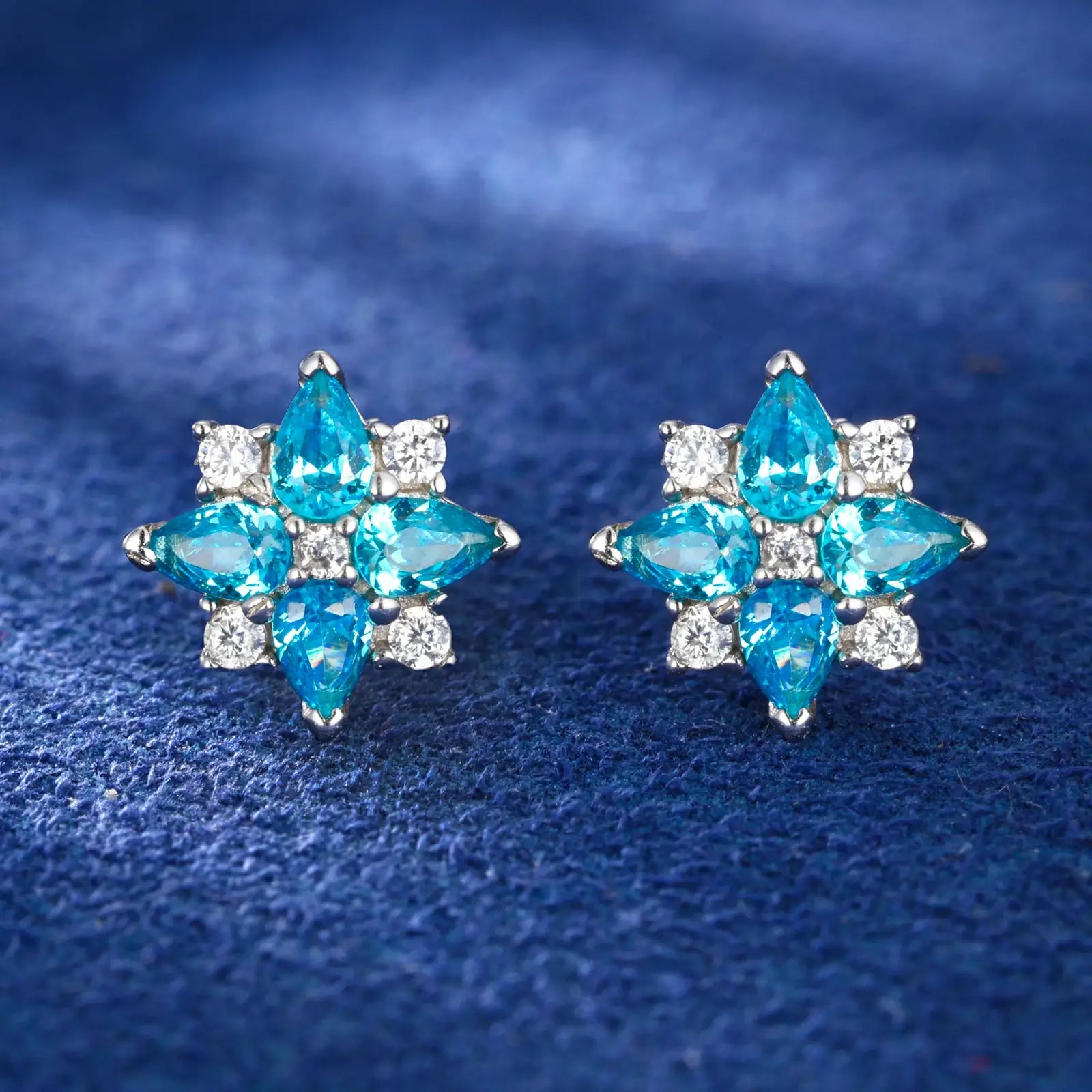 White gold 925 sterling silver moissanite lucky star clover stud earrings full display on blue table — showcasing star-clover design, moissanite sparkle & zircon vibrancy, 925 silver craftsmanship