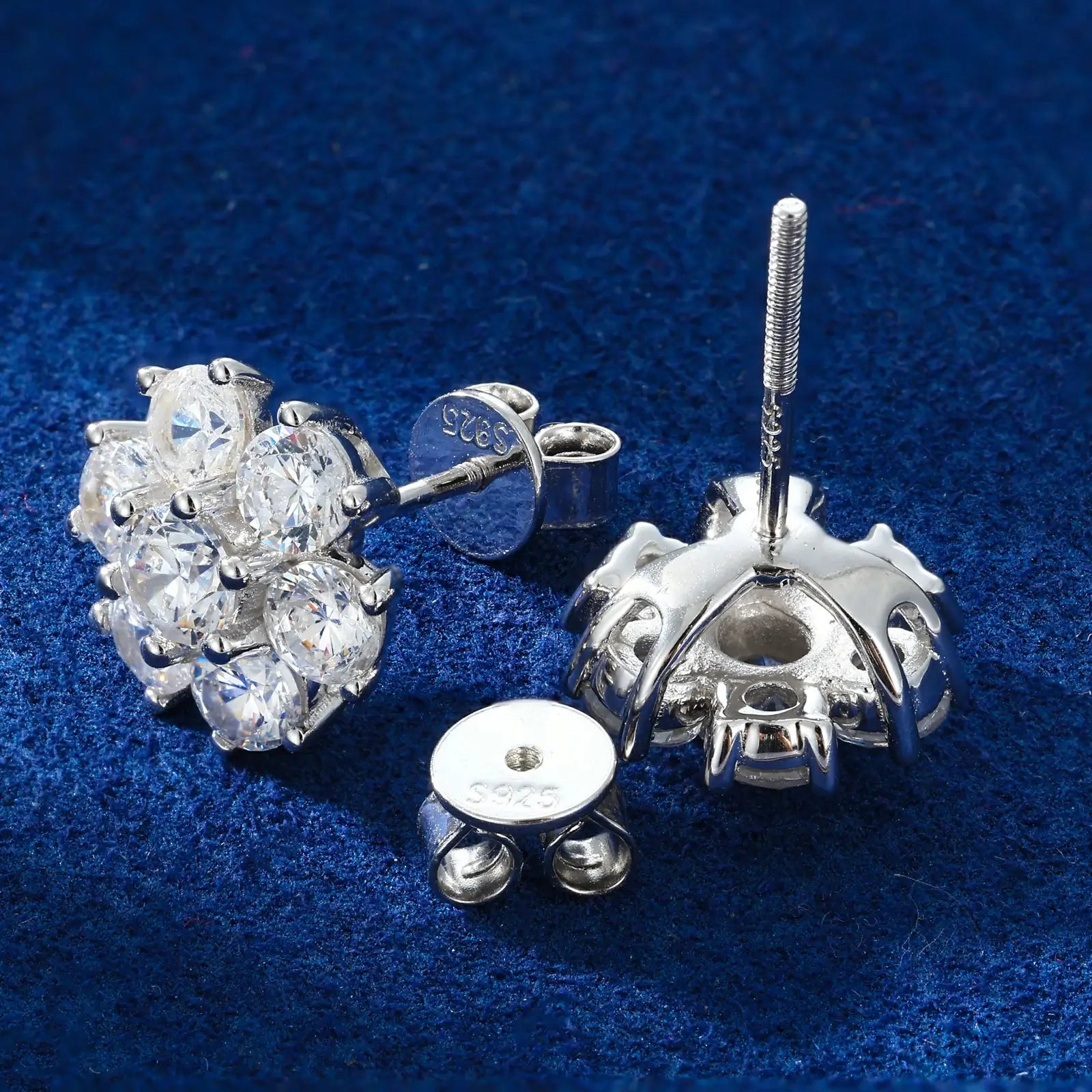 Back close-up of white gold 925 sterling silver moissanite radiance flower stud earring on blue table — showcasing 925 silver post, secure backing, floral design from behind