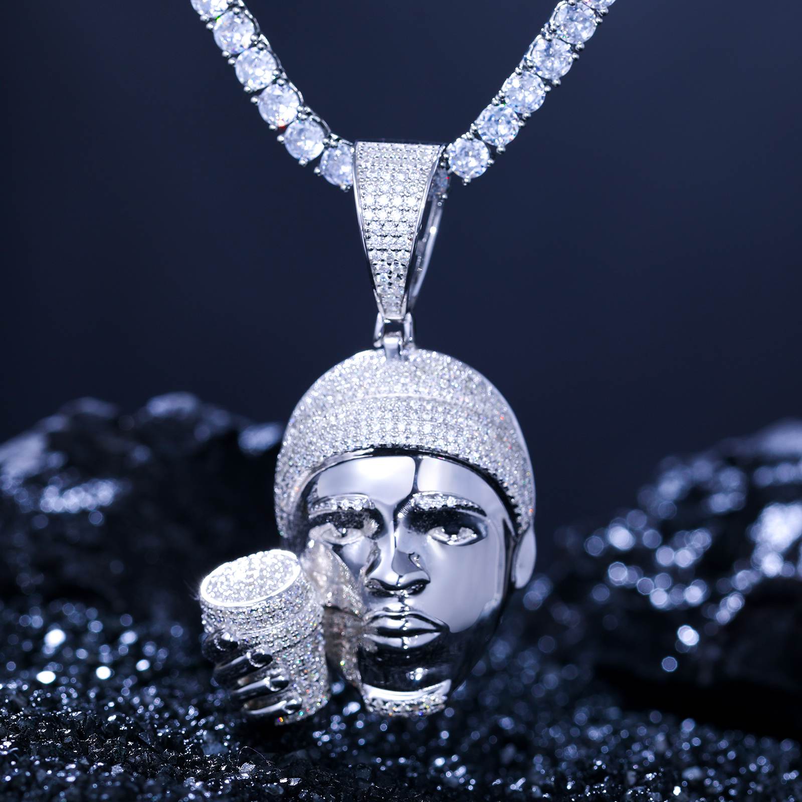 Pendent dangling 925 silver rapper head cup with VVS moissanite, glowing against velvet darkness - Luxury streetwear statement