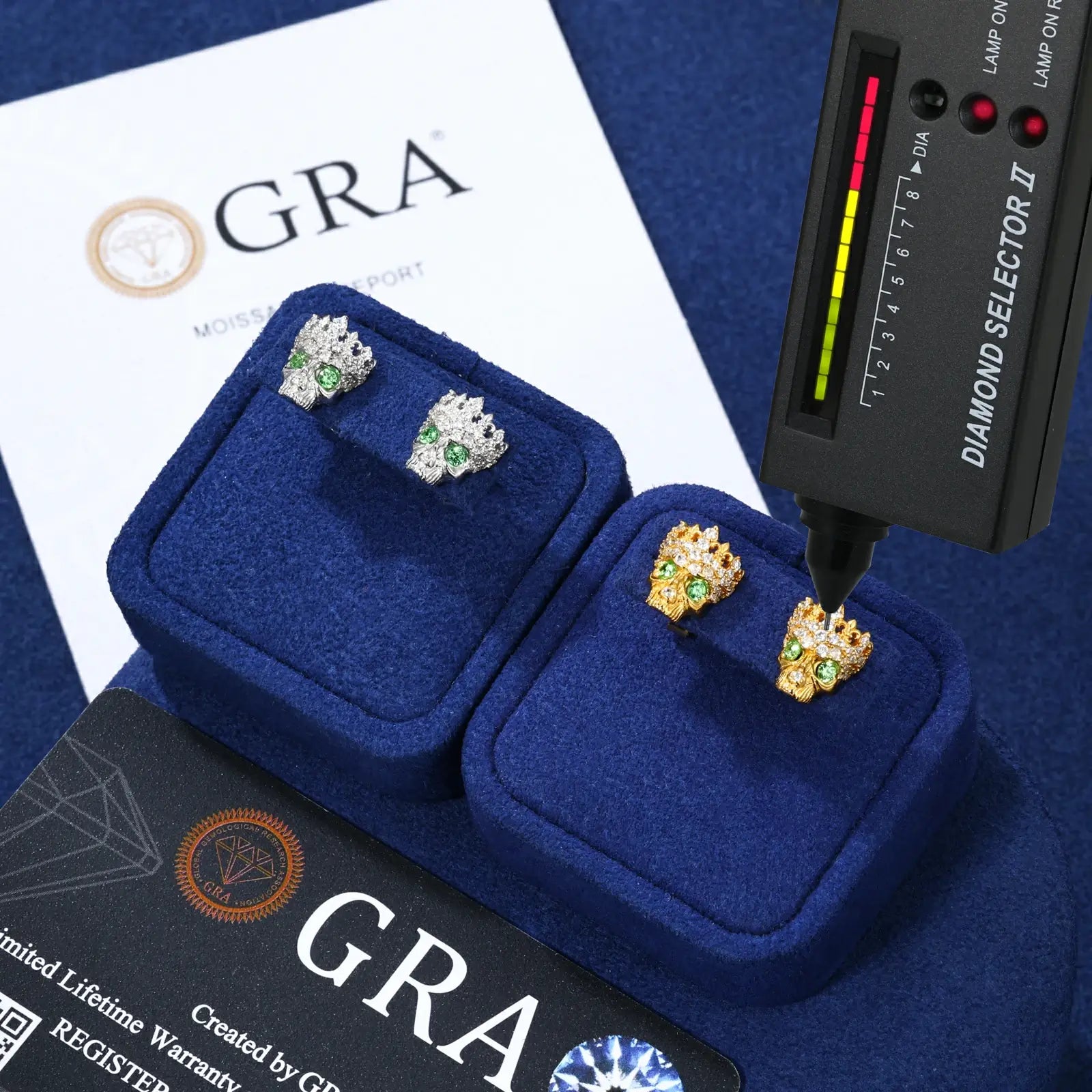 White & yellow gold 925 sterling silver moissanite Chrome Hearts crown skull stud earrings with diamond tester + GRA certificate on blue table — certified moissanite, 925 silver durability, unique dark-luxury crown-skull design with zircon accent