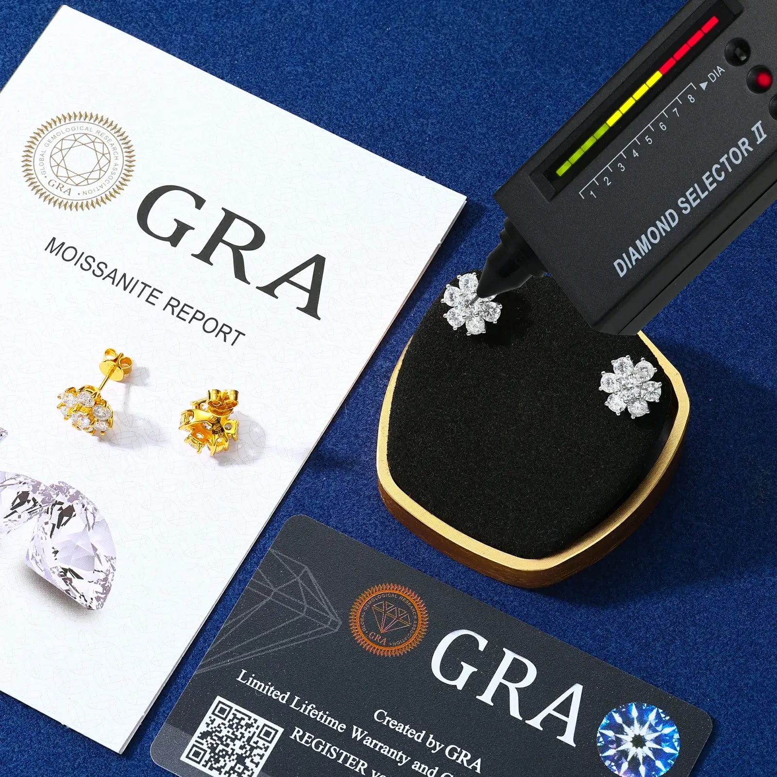 White & yellow gold 925 sterling silver moissanite radiance flower stud earrings with diamond tester + GRA certificate on blue table — certified moissanite, 925 silver durability, floral radiance design