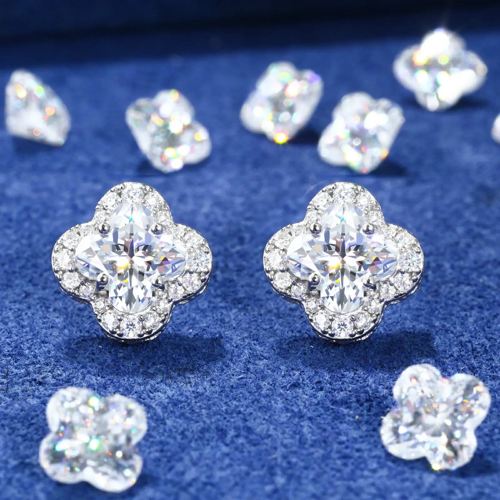 Yellow gold 925 sterling silver lily cut moissanite four leaf clover stud earrings full display on blue table — showcasing lucky clover design, lily-cut moissanite sparkle, 925 silver craftsmanship