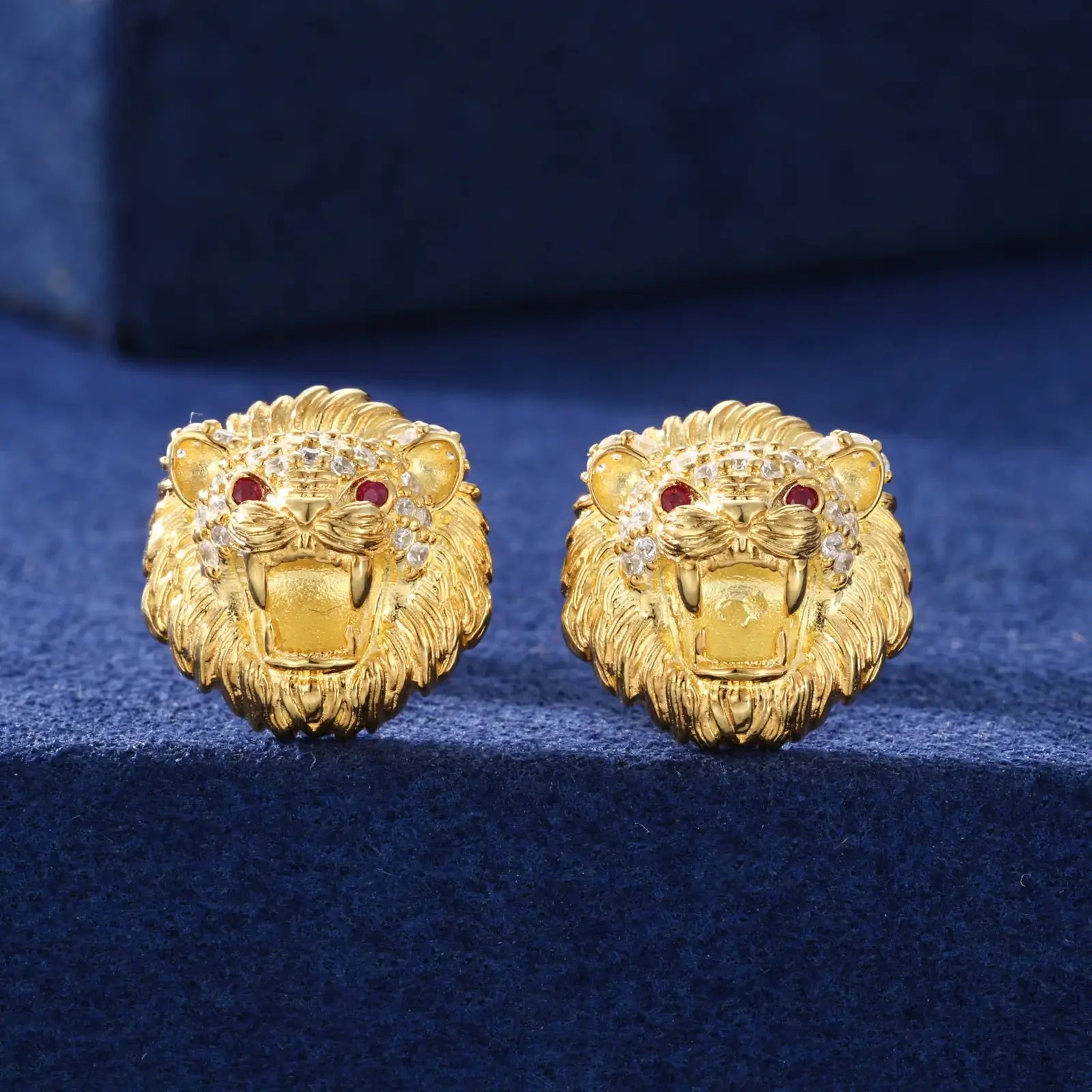 Yellow gold 925 sterling silver moissanite little lion stud earrings full display on blue table — showcasing fierce lion design, moissanite sparkle, 925 silver craftsmanship