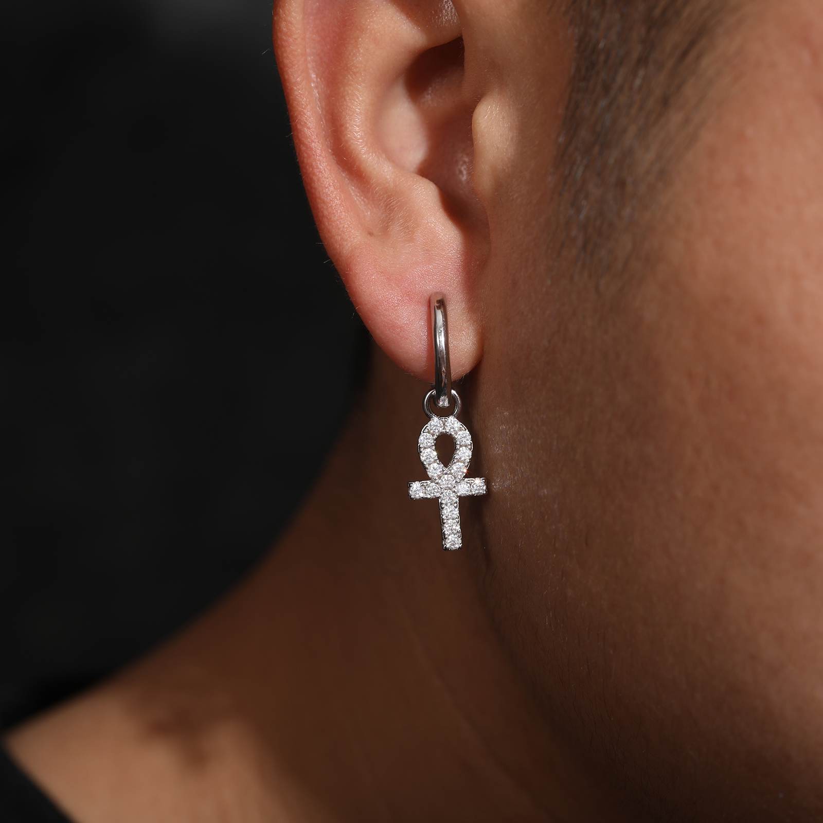 a rapper wear a ankh cross earring in white gold color