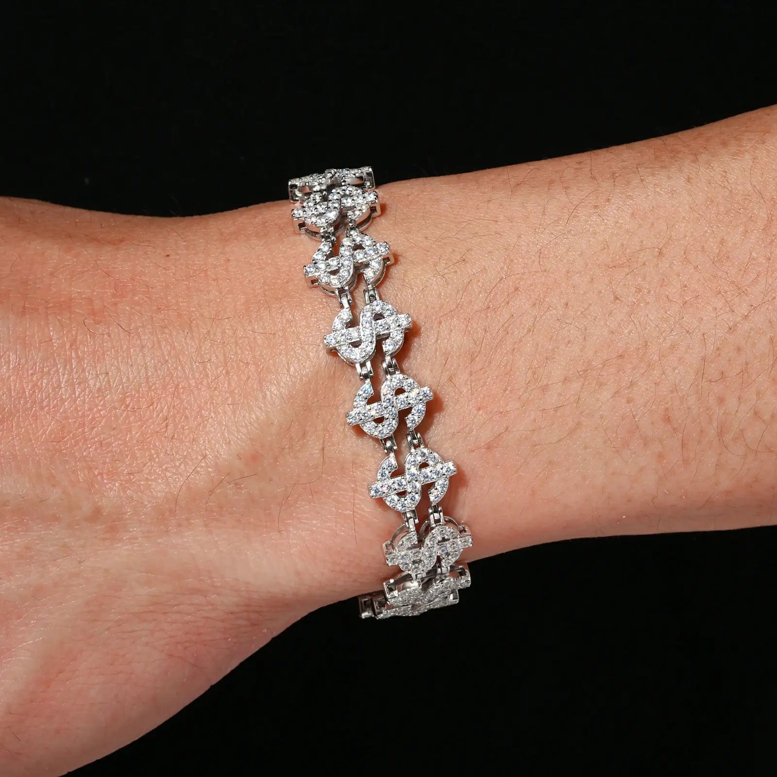 African American woman wearing 12mm white gold plated S925 dollar bracelet - moissanite-paved $ links shining against dark skin for boardroom-to-bar luxury