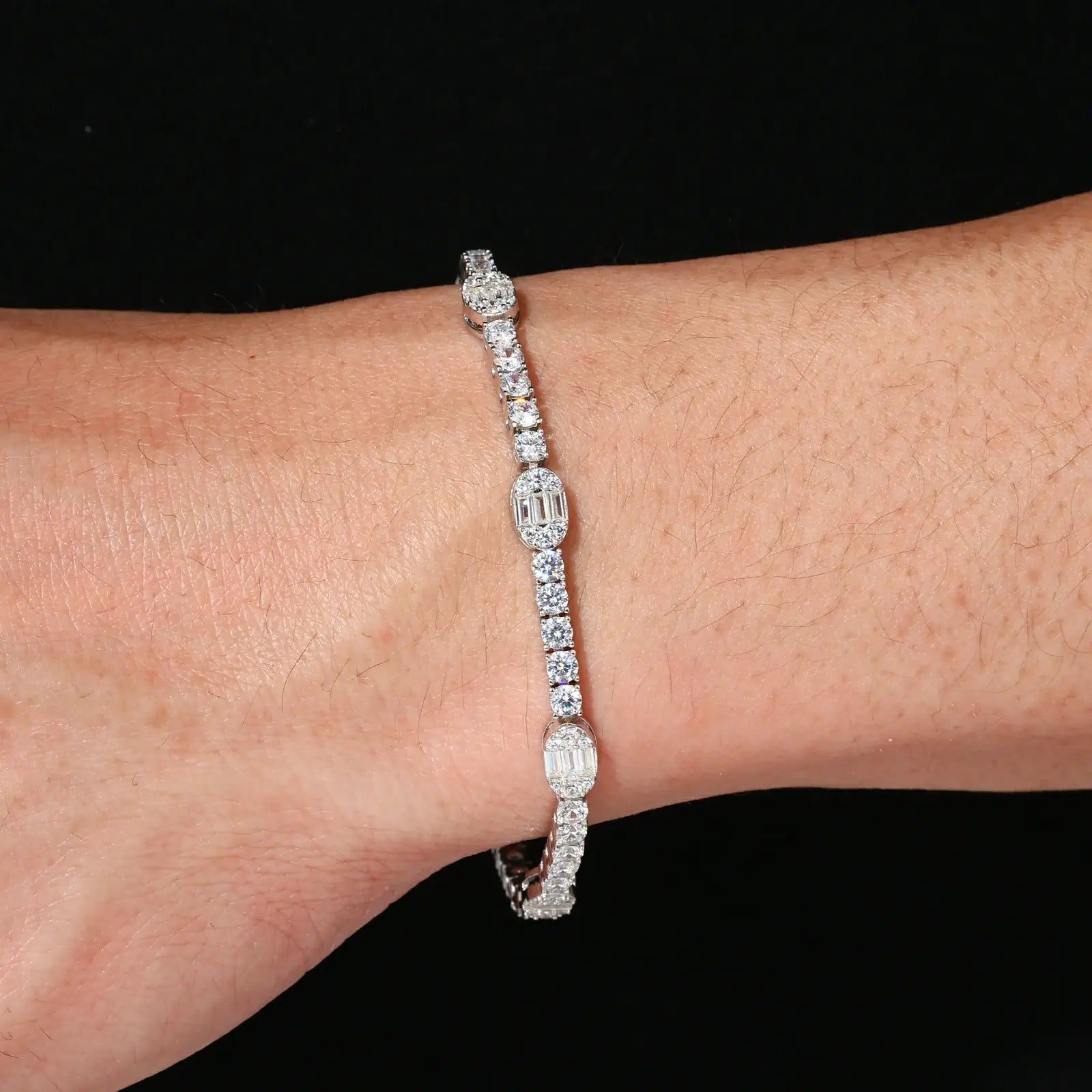 African American woman wearing 5.5mm white gold pills tennis bracelet - geometric moissanite links shining against dark skin for gym-to-gala style