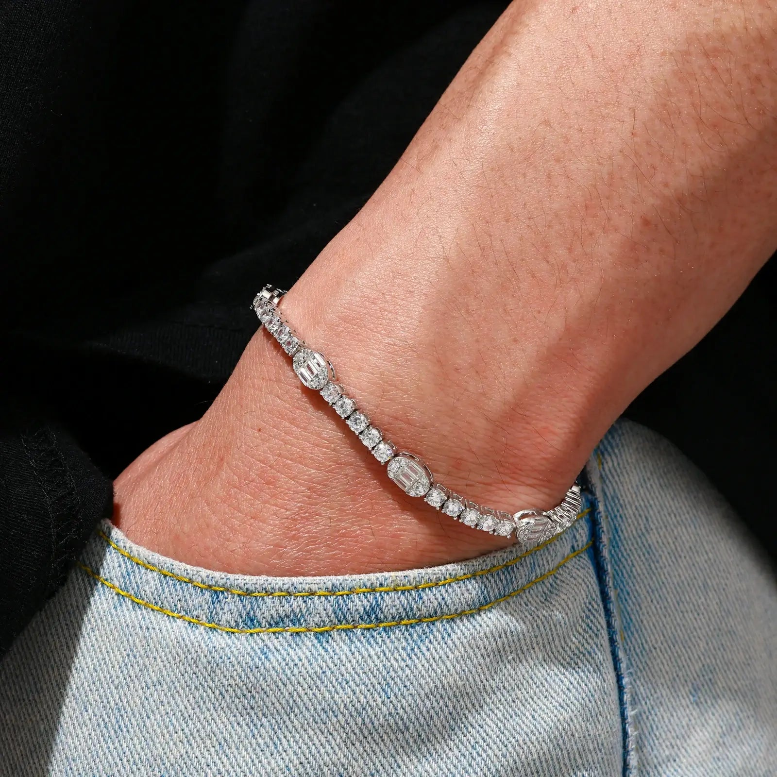 Detailed wrist shot: 5.5mm S925 pills bracelet on Black model - alternating round/baguette moissanites under sunset light