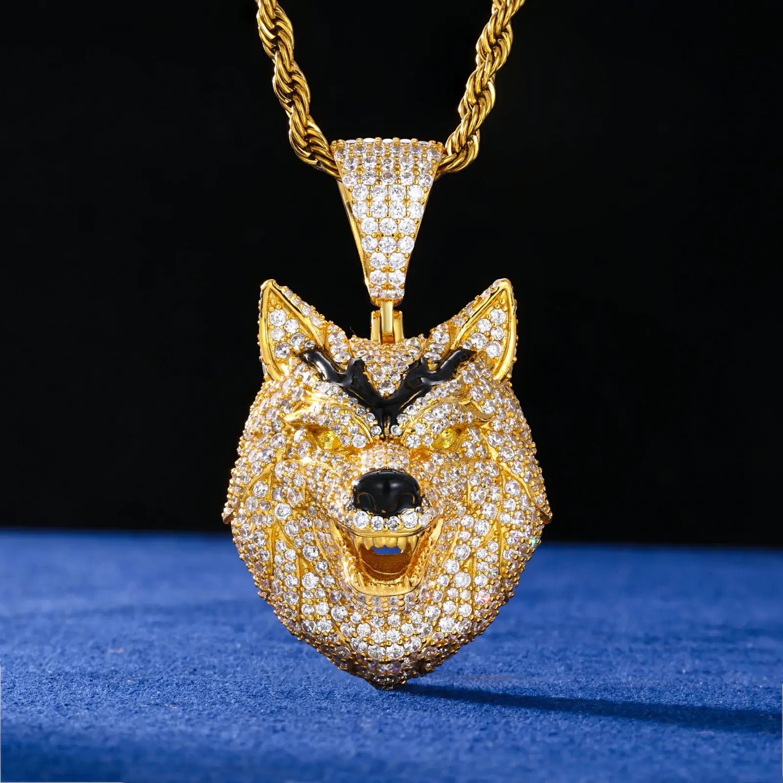 Gold wolf head pendant hanging on blue table - 925 sterling silver with full moissanite pave and fierce animal jewelry design