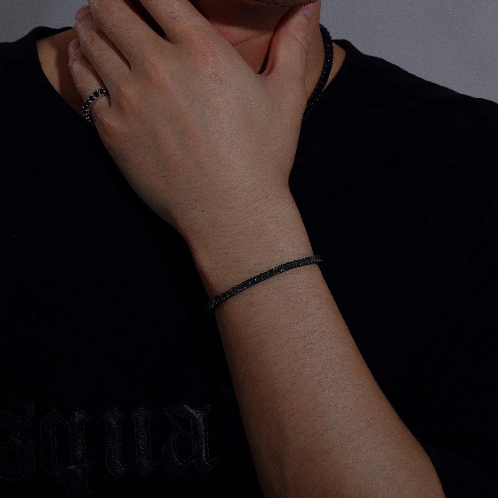 Male model wearing 3mm black moissanite tennis bracelet, front view highlighting urban luxury style and contemporary men's jewelry trend