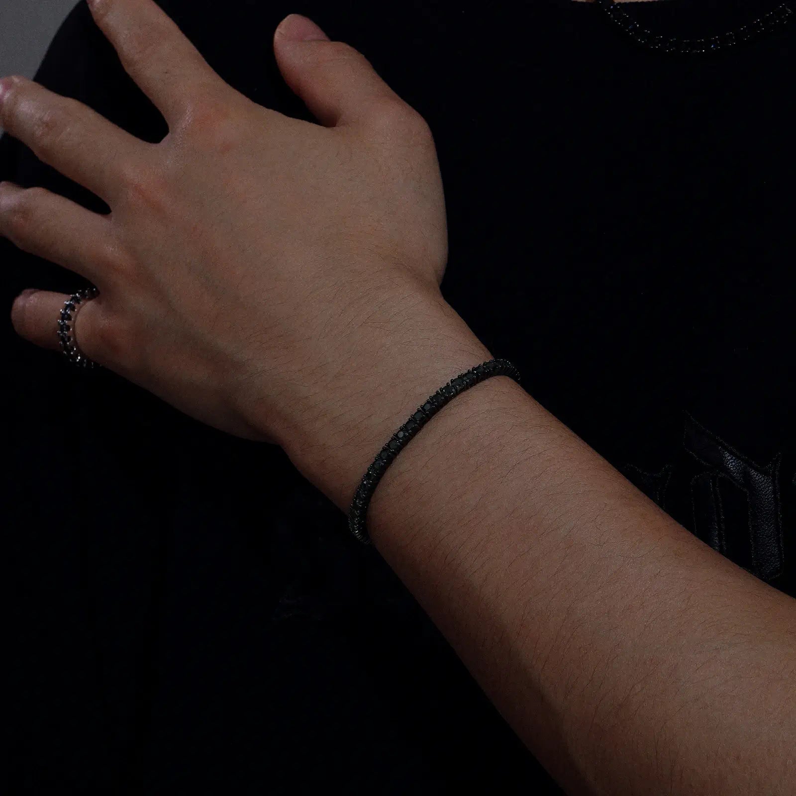 Side view of male model wearing 3mm black moissanite tennis bracelet, demonstrating perfect fit and modern masculine accessories