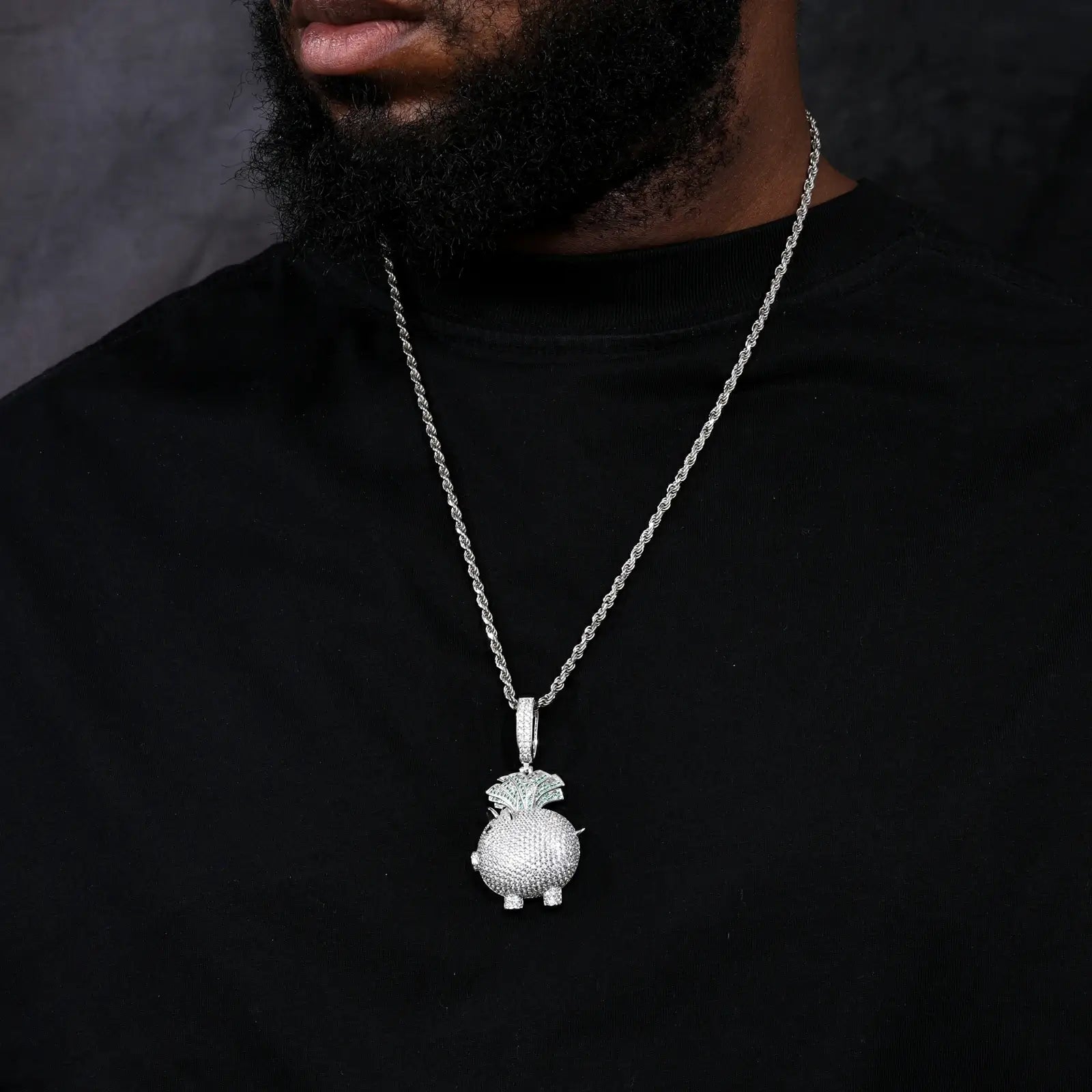 Caucasian man in profile wearing white gold piggy pendant - S925 moissanite body with green cash fan detail | Waterproof abundance symbol