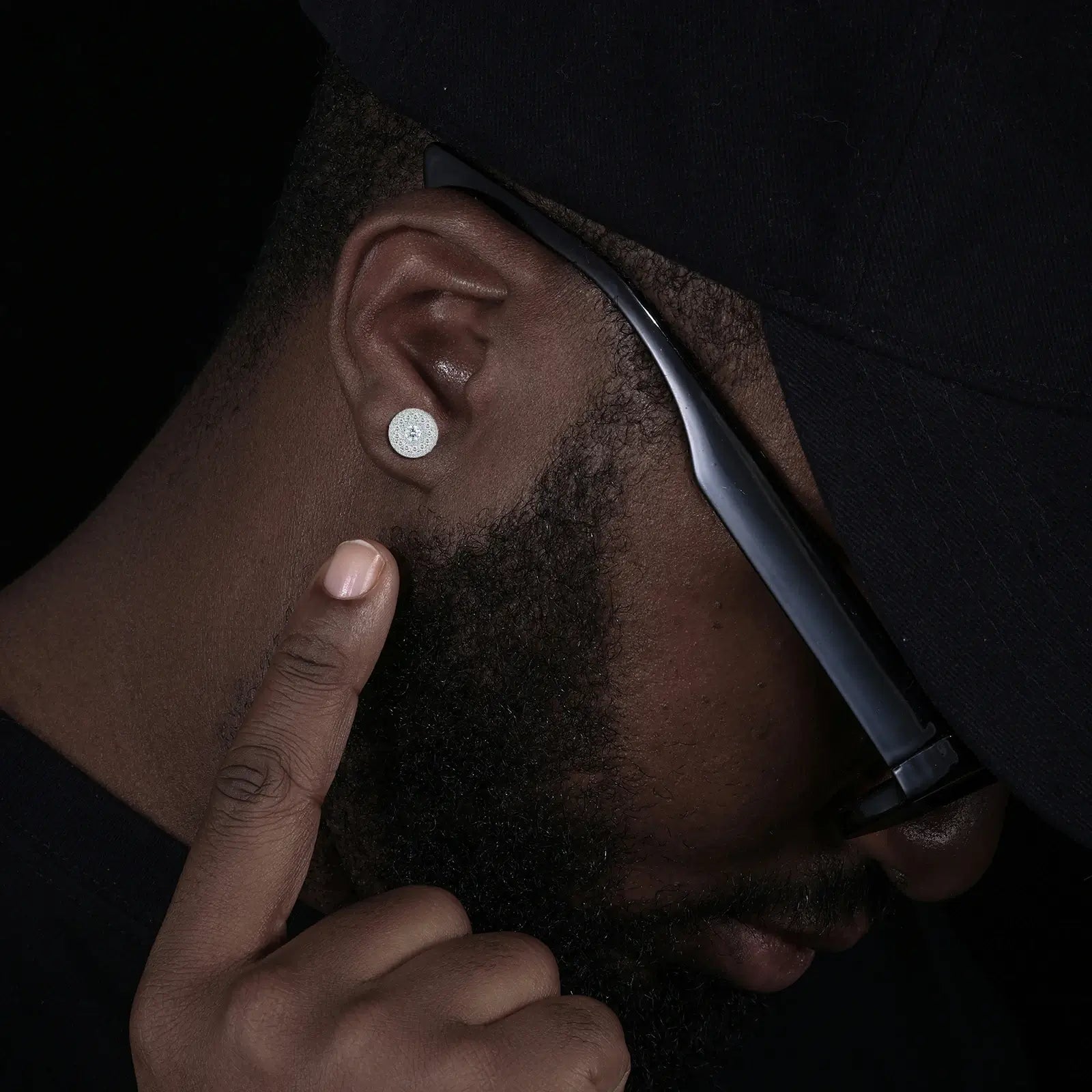 Male fashion model showcasing halo cluster earrings - S925 white gold setting contrasting with dark skin | Gender-neutral luxury jewelry for formal events