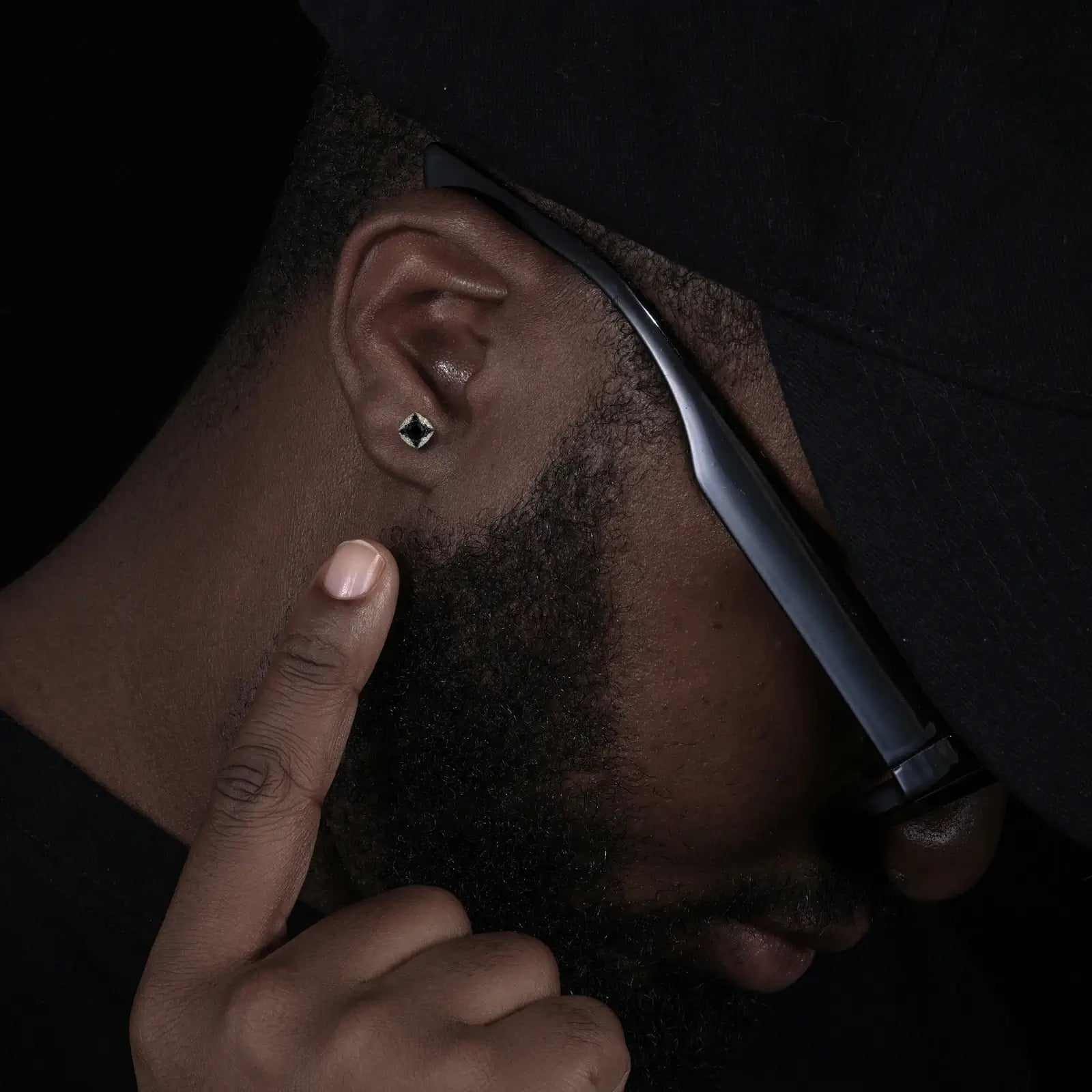 Caucasian man wearing black star stud earrings - S925 silver with moissanite halo | Men's occult-inspired luxury