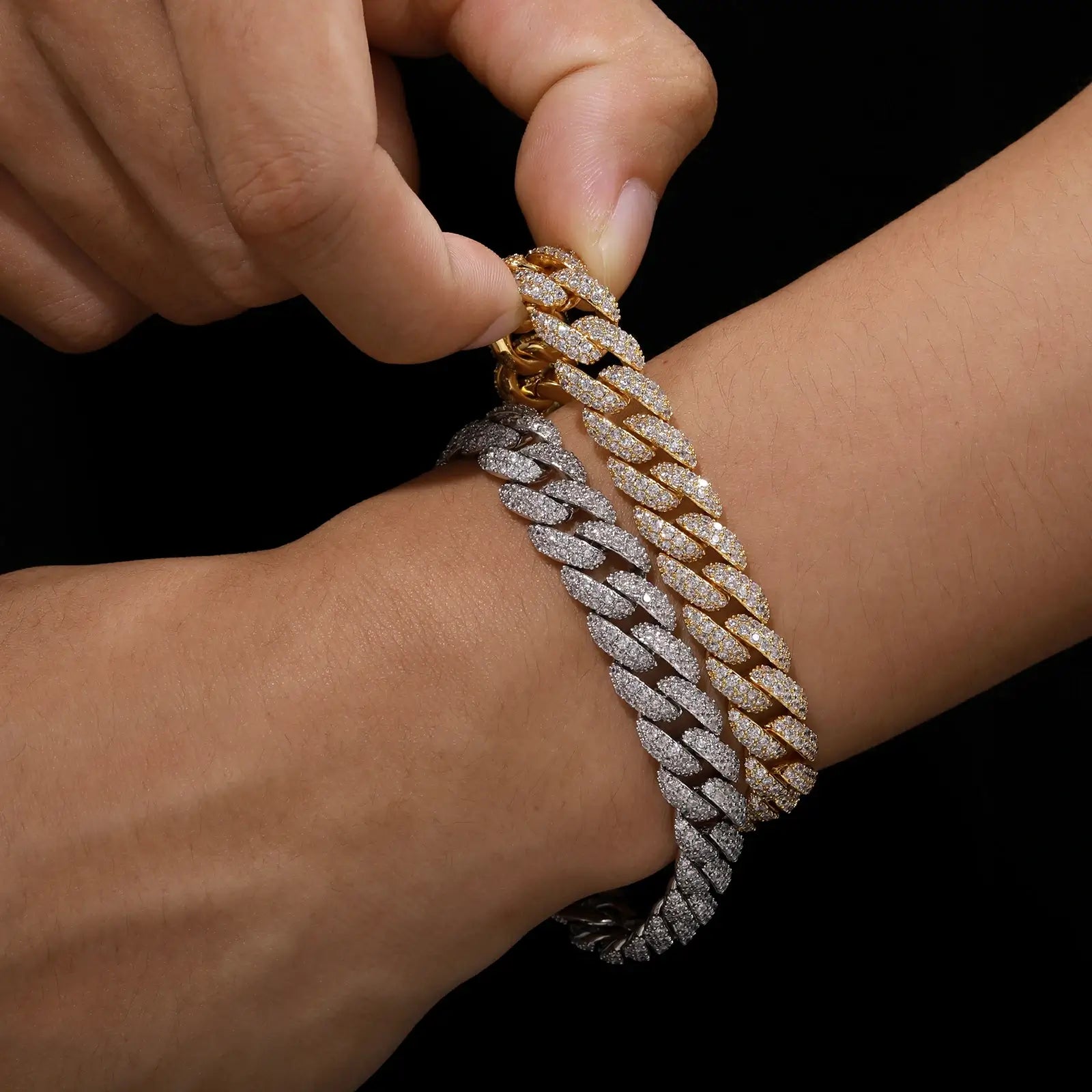 Close-up wrist shot of male model wearing white and yellow gold Cuban bracelets with brilliant CZ stones, ideal for bling jewelry enthusiasts.