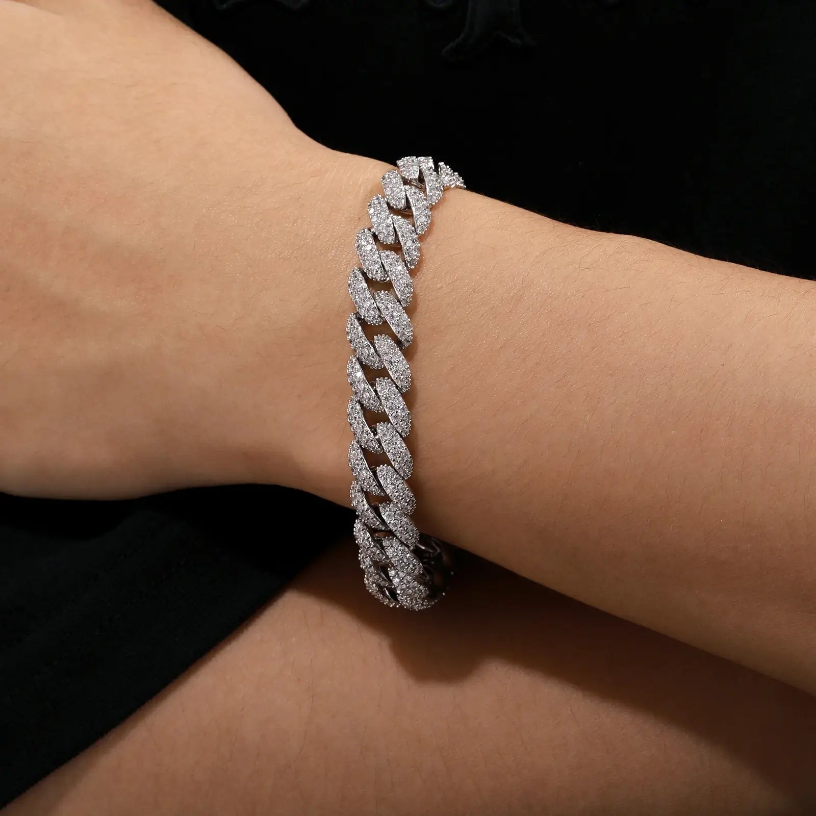Male model showcasing white gold Cuban link bracelet with diamond-cut CZ stones, perfect for luxury men's jewelry and urban fashion.
