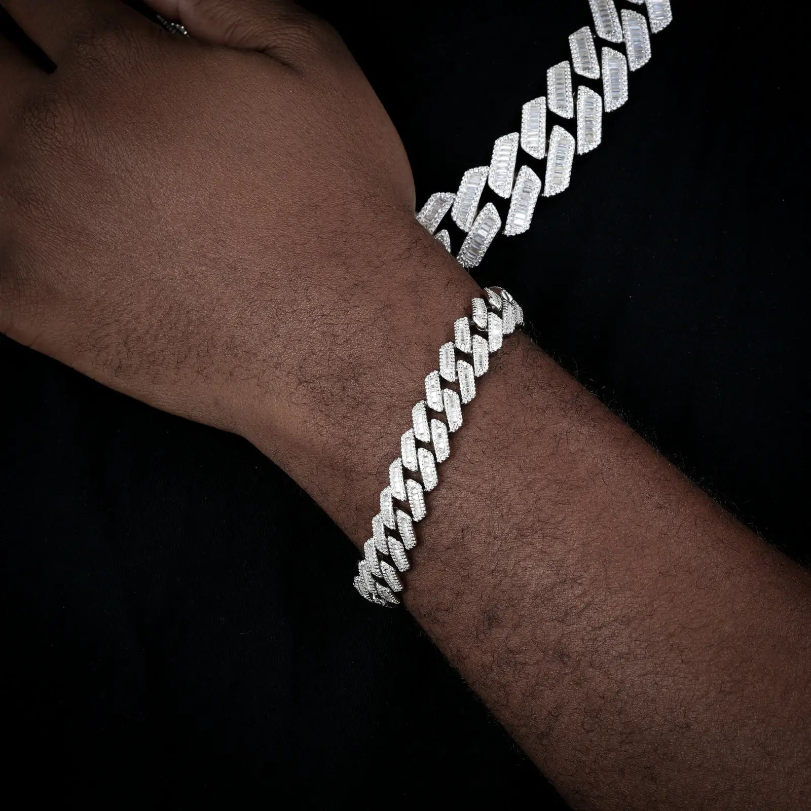 Male model showcasing 14mm white gold Cuban link bracelet with baguette moissanite stones, perfect for luxury men's jewelry and hip-hop fashion enthusiasts.