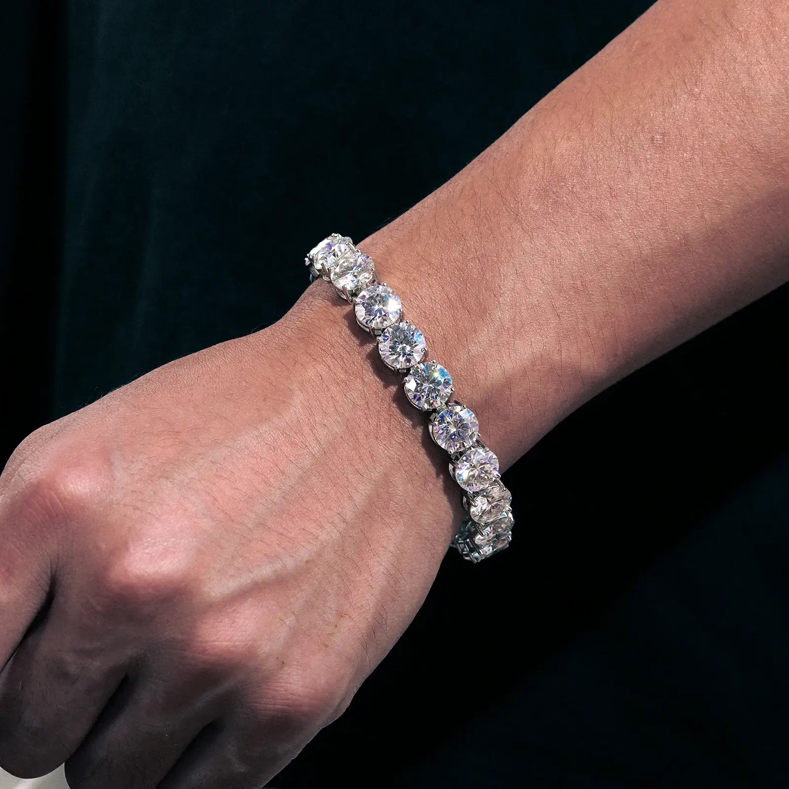 Male model wearing 10mm white gold moissanite tennis bracelet with 11-stone setting, showcasing luxury men's jewelry for formal occasions.