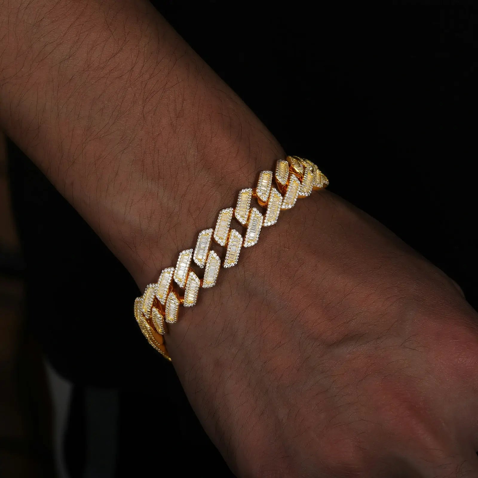 Stylish man wearing 14mm yellow gold Cuban link bracelet featuring baguette moissanite stones, ideal for luxury streetwear and men's accessories.